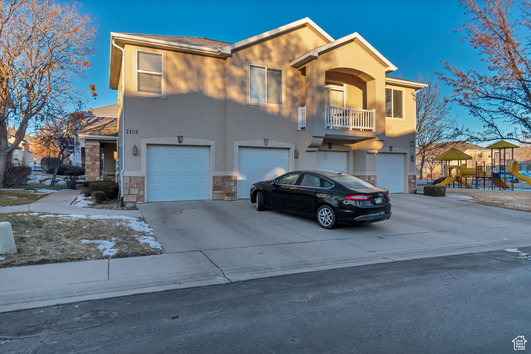 View of front of home with a garage and a playground