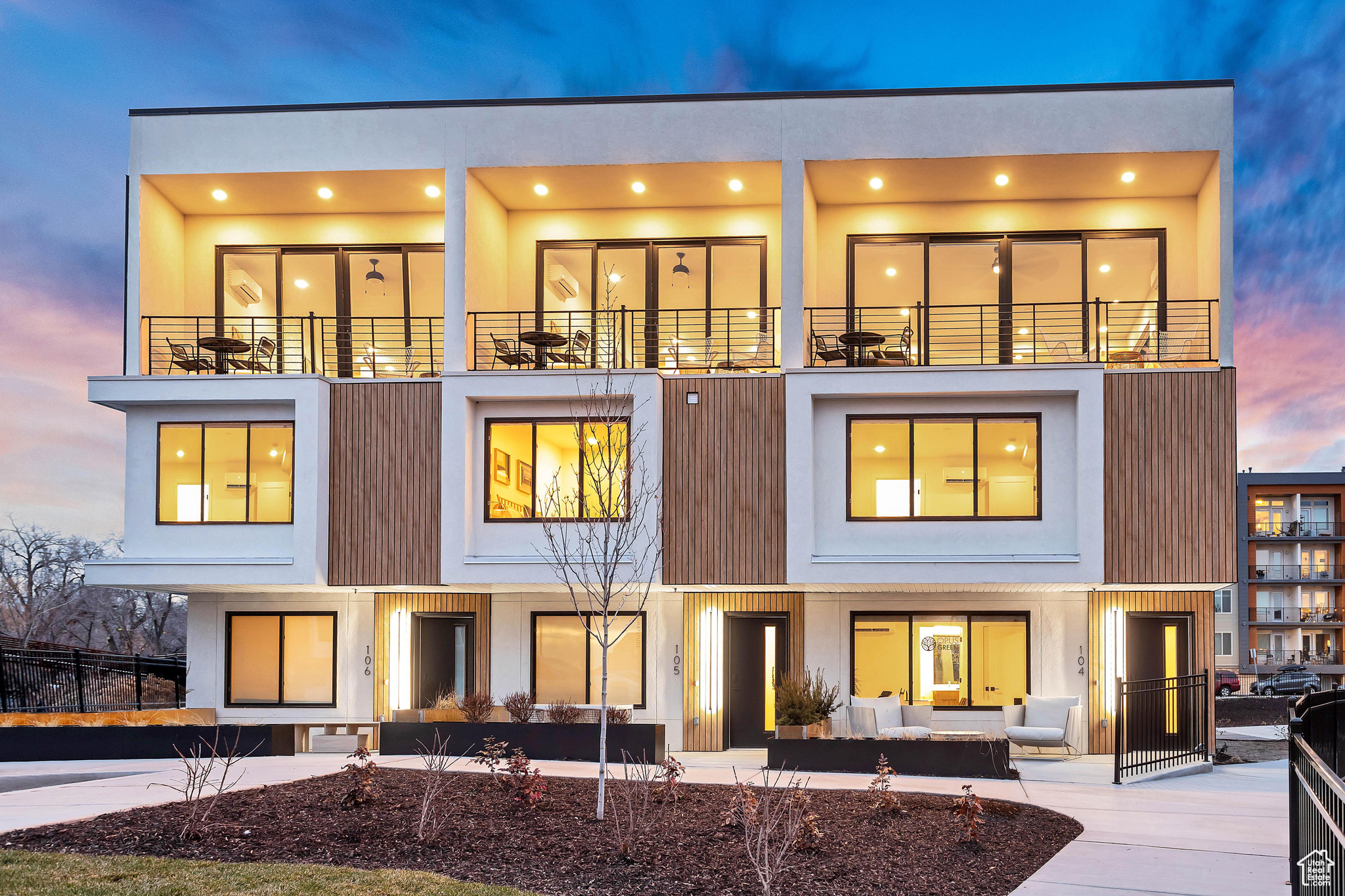 Back house at dusk with an outdoor hangout area and a balcony