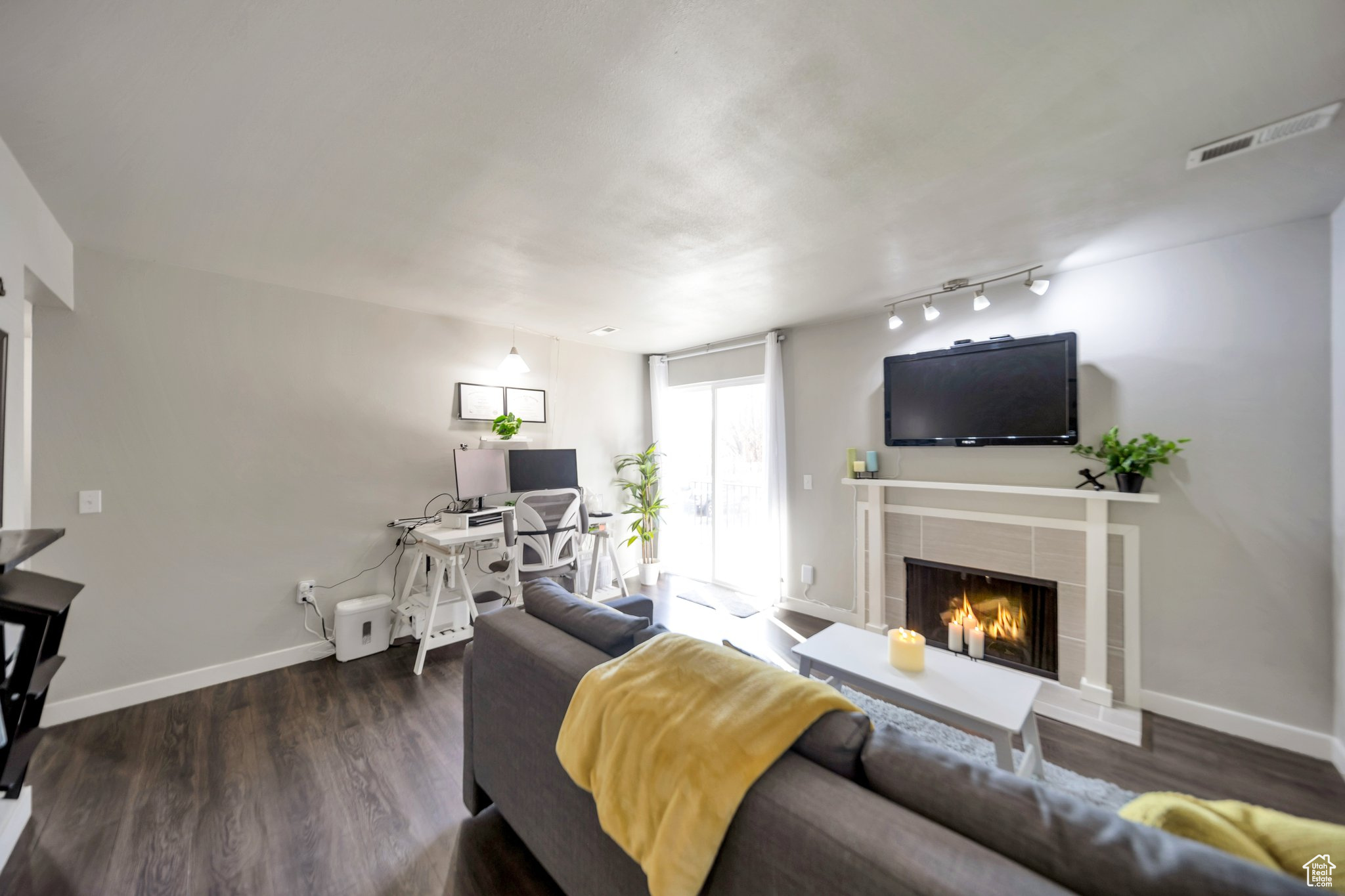 Living room featuring dark hardwood / wood-style flooring and a tile fireplace