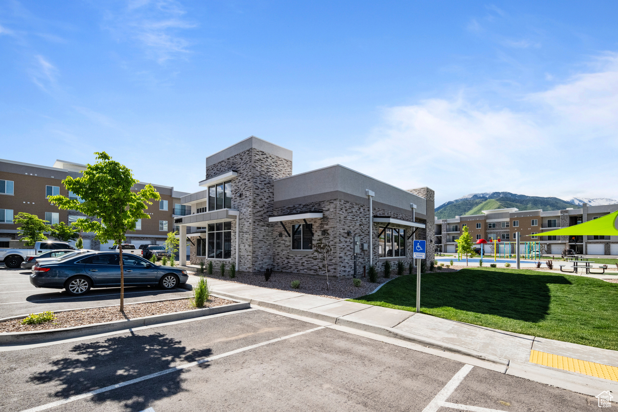 View of parking with a yard and a mountain view