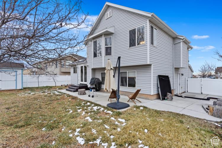 Back of property with a lawn and a patio