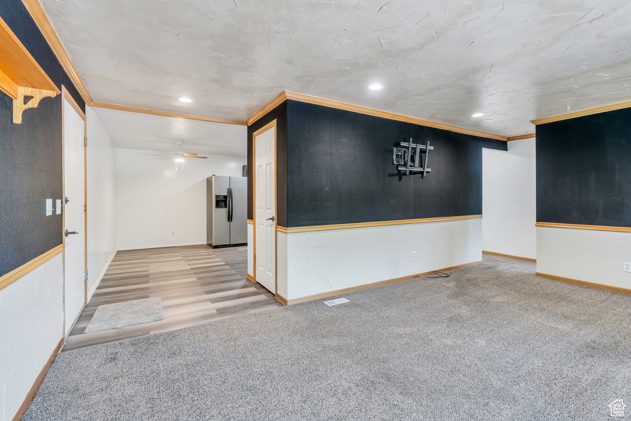 Unfurnished room featuring ceiling fan, ornamental molding, and carpet flooring