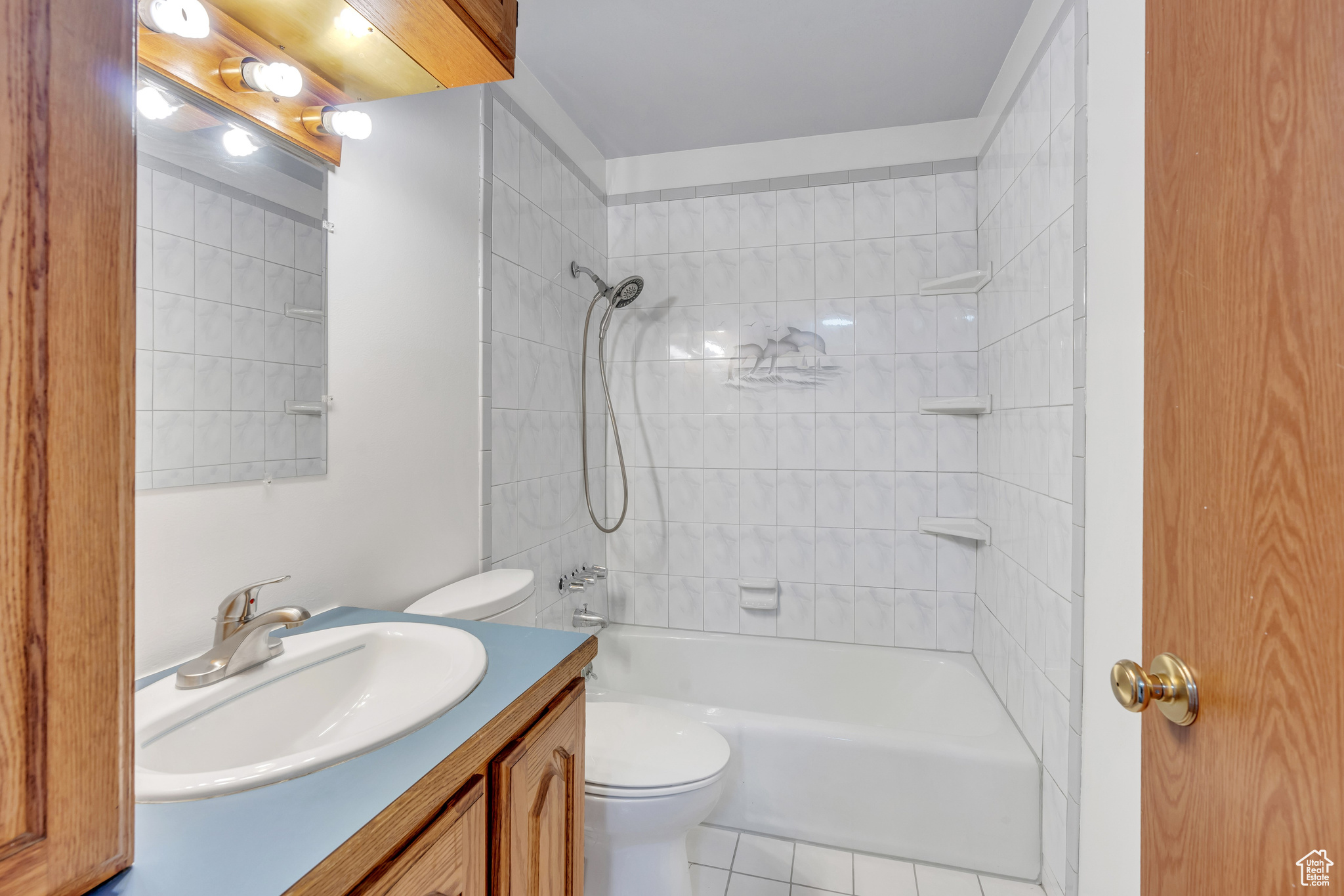 Full bathroom featuring tiled shower / bath, vanity, toilet, and tile patterned flooring