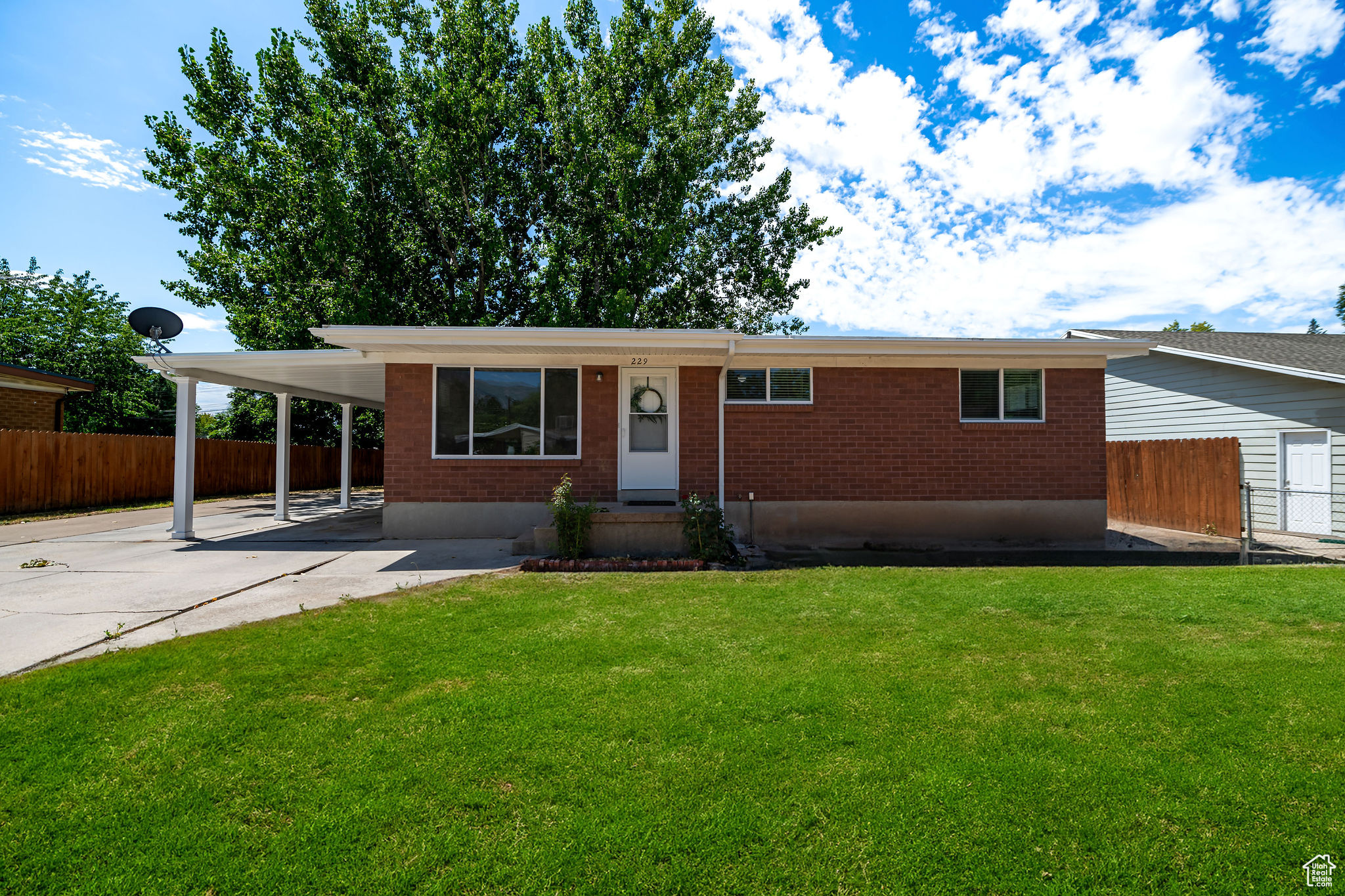 Ranch-style house with a carport and a front yard