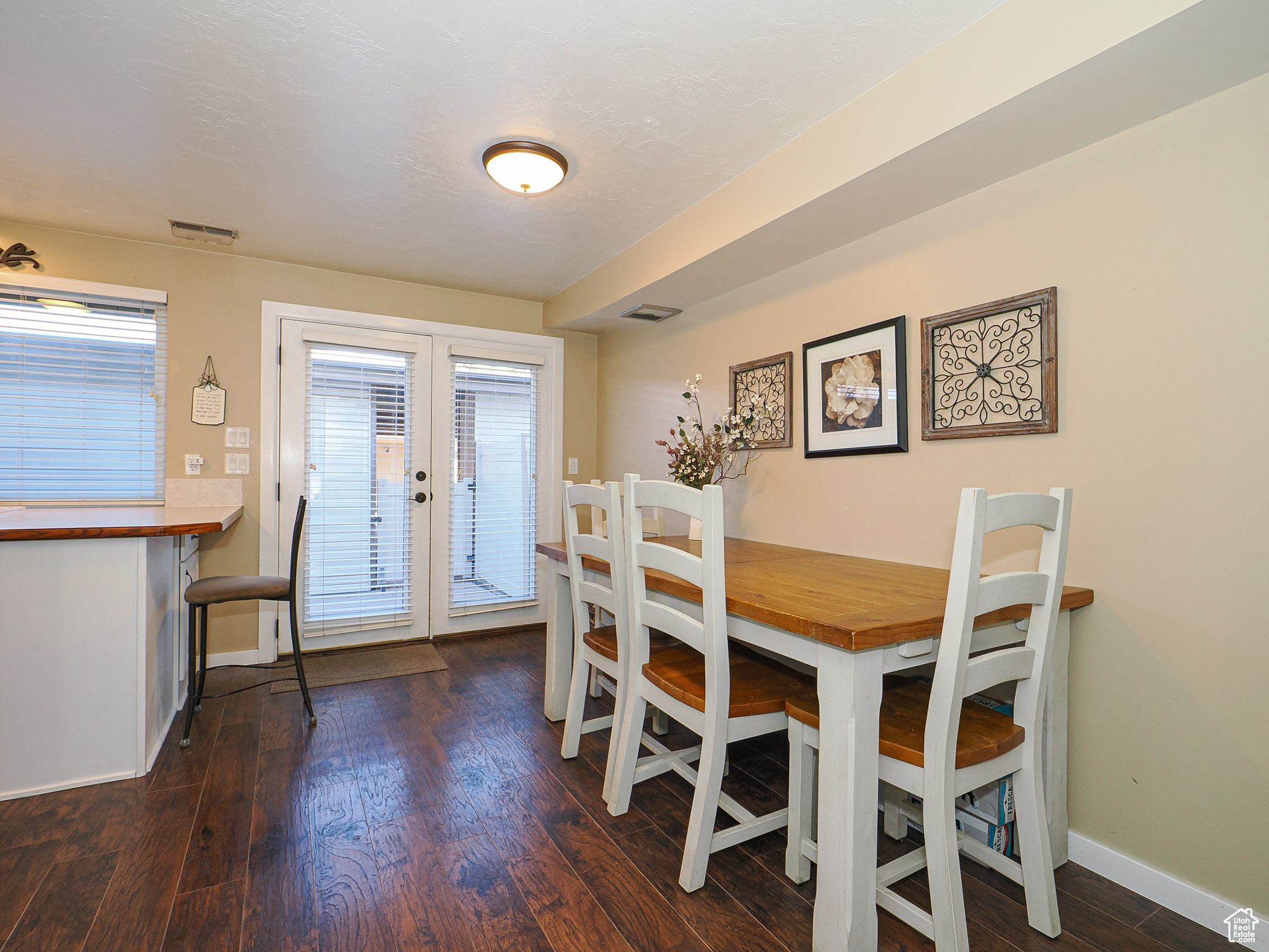 Dining space with dark wood-type flooring and french doors