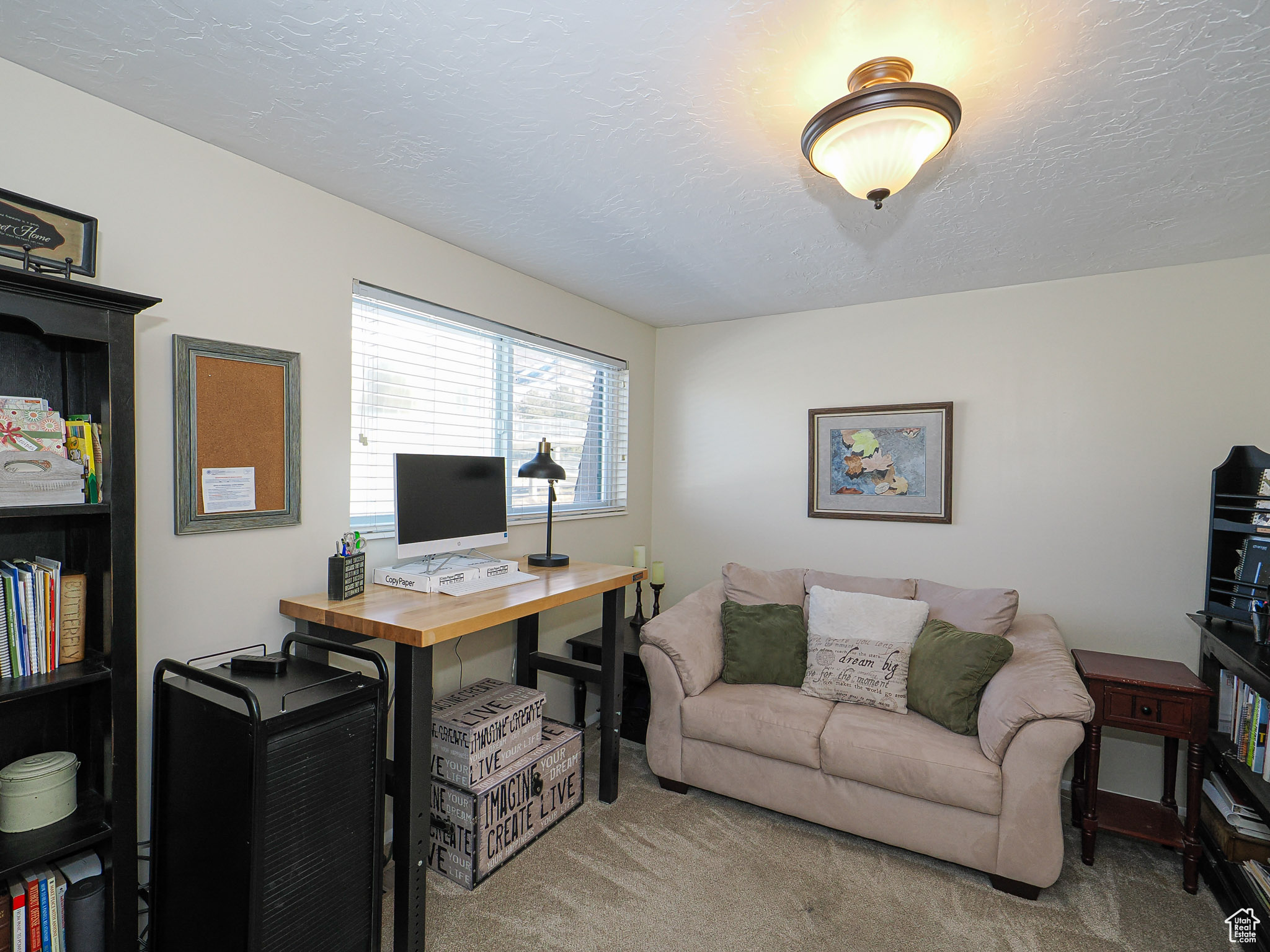 Carpeted office space with a textured ceiling