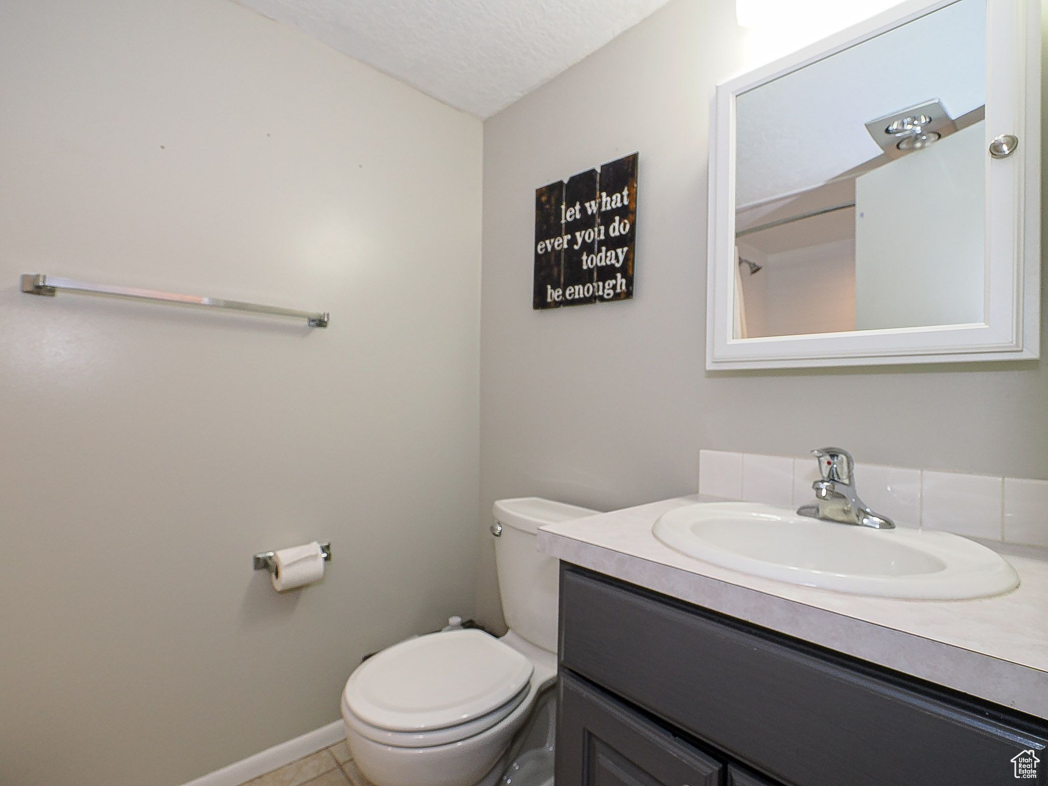 Bathroom with tile patterned floors, vanity, toilet, and a textured ceiling