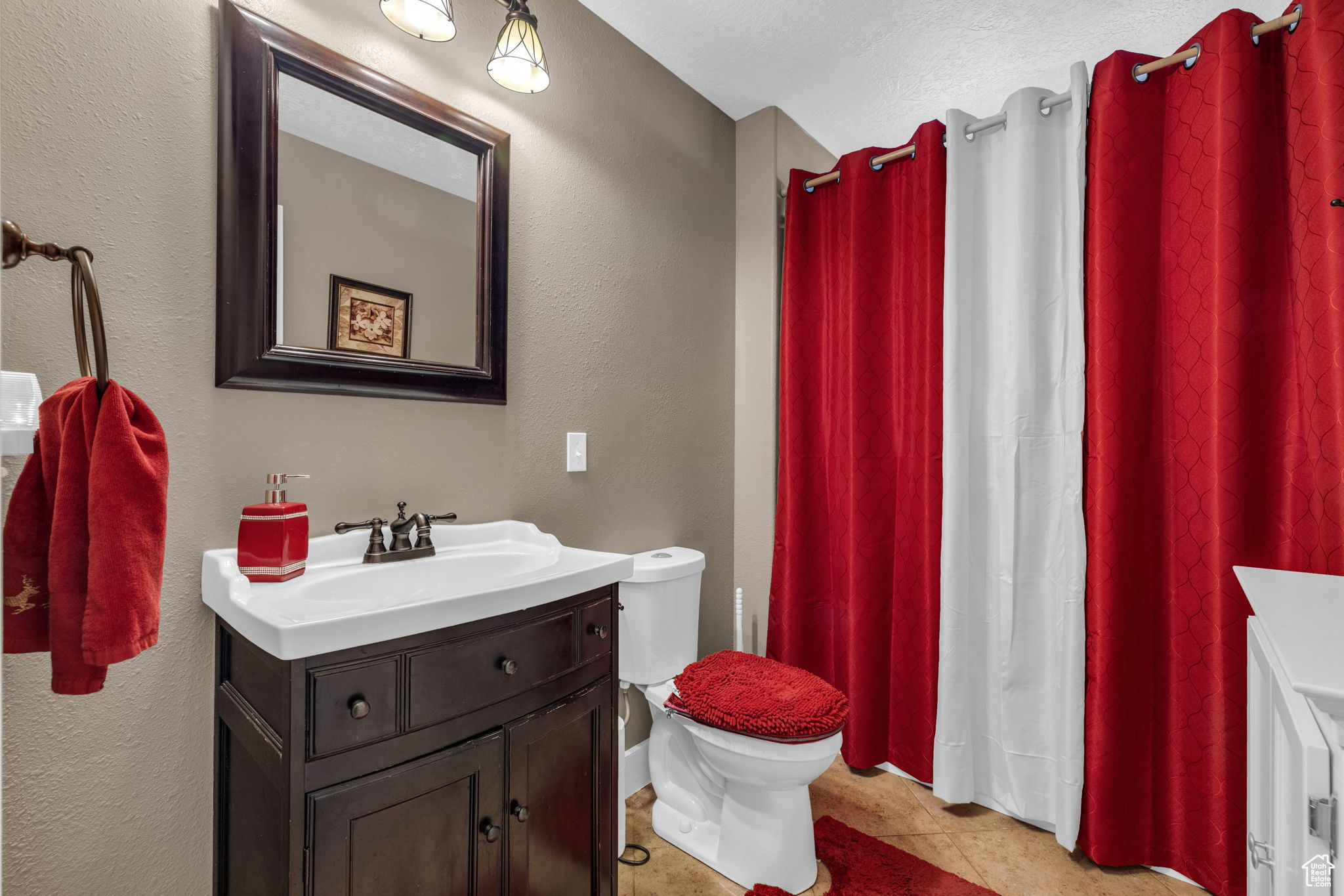 Bathroom with vanity, toilet, and tile patterned flooring