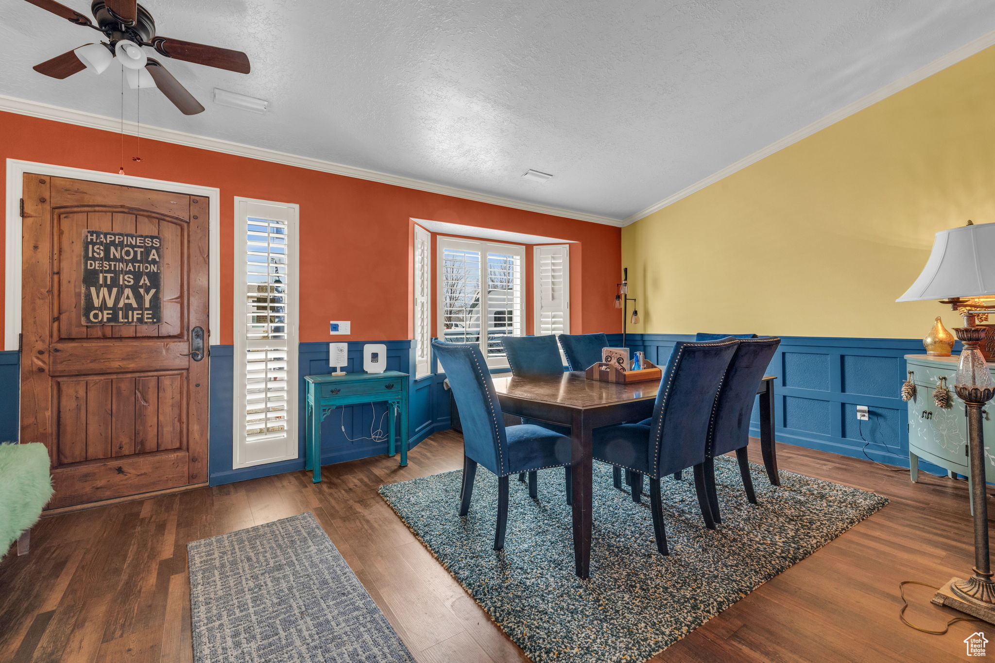 Dining room featuring ornamental molding, dark hardwood / wood-style floors, and a textured ceiling