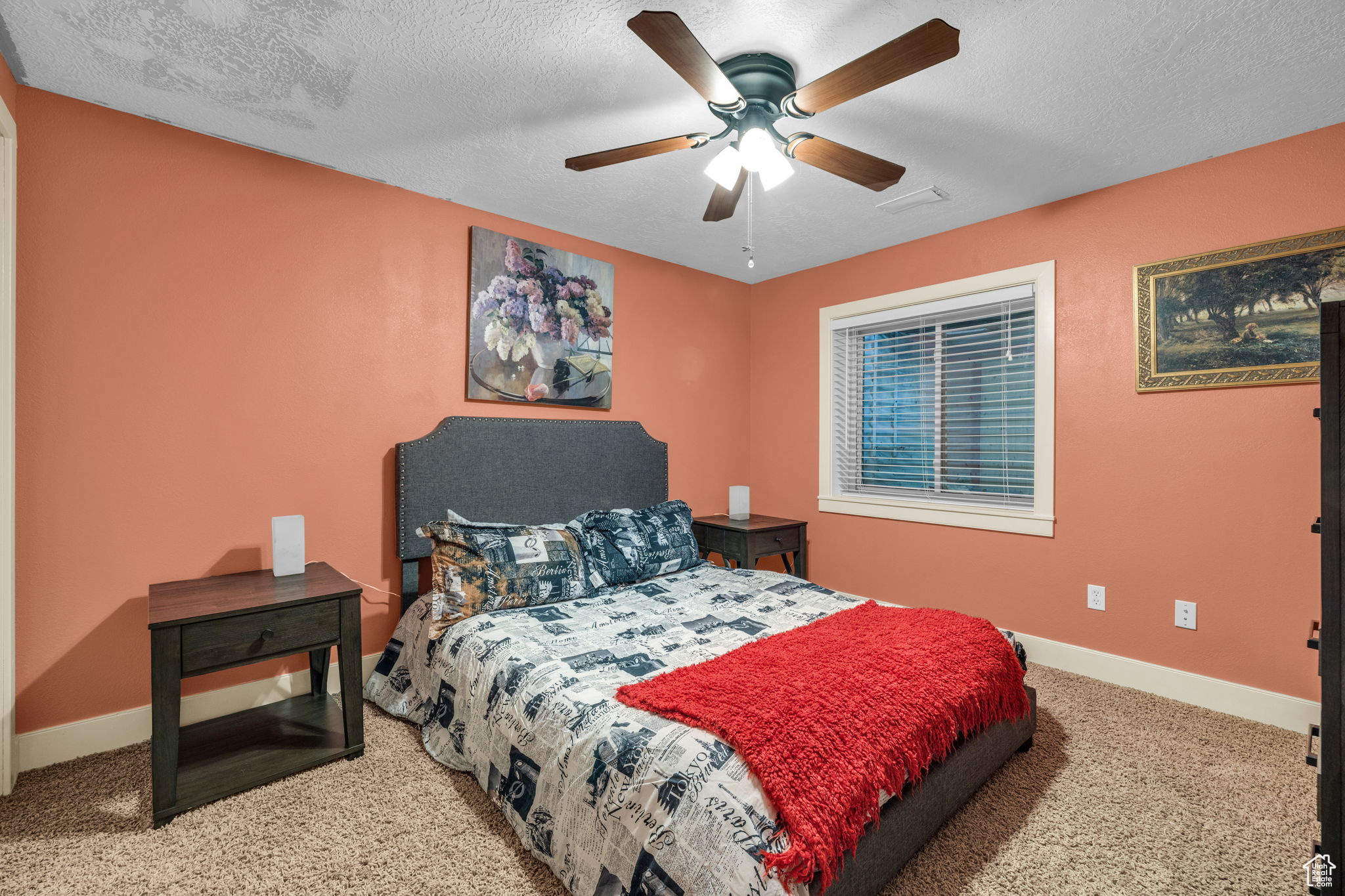 Carpeted bedroom featuring ceiling fan and a textured ceiling