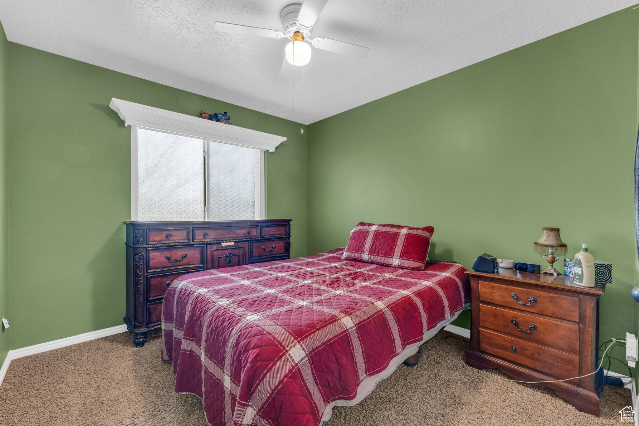 Bedroom featuring ceiling fan and a textured ceiling