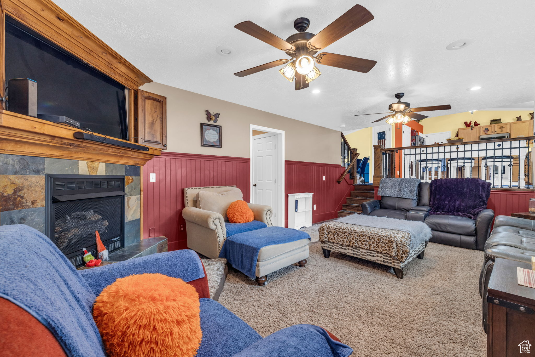 Living room with a fireplace, wood walls, and carpet