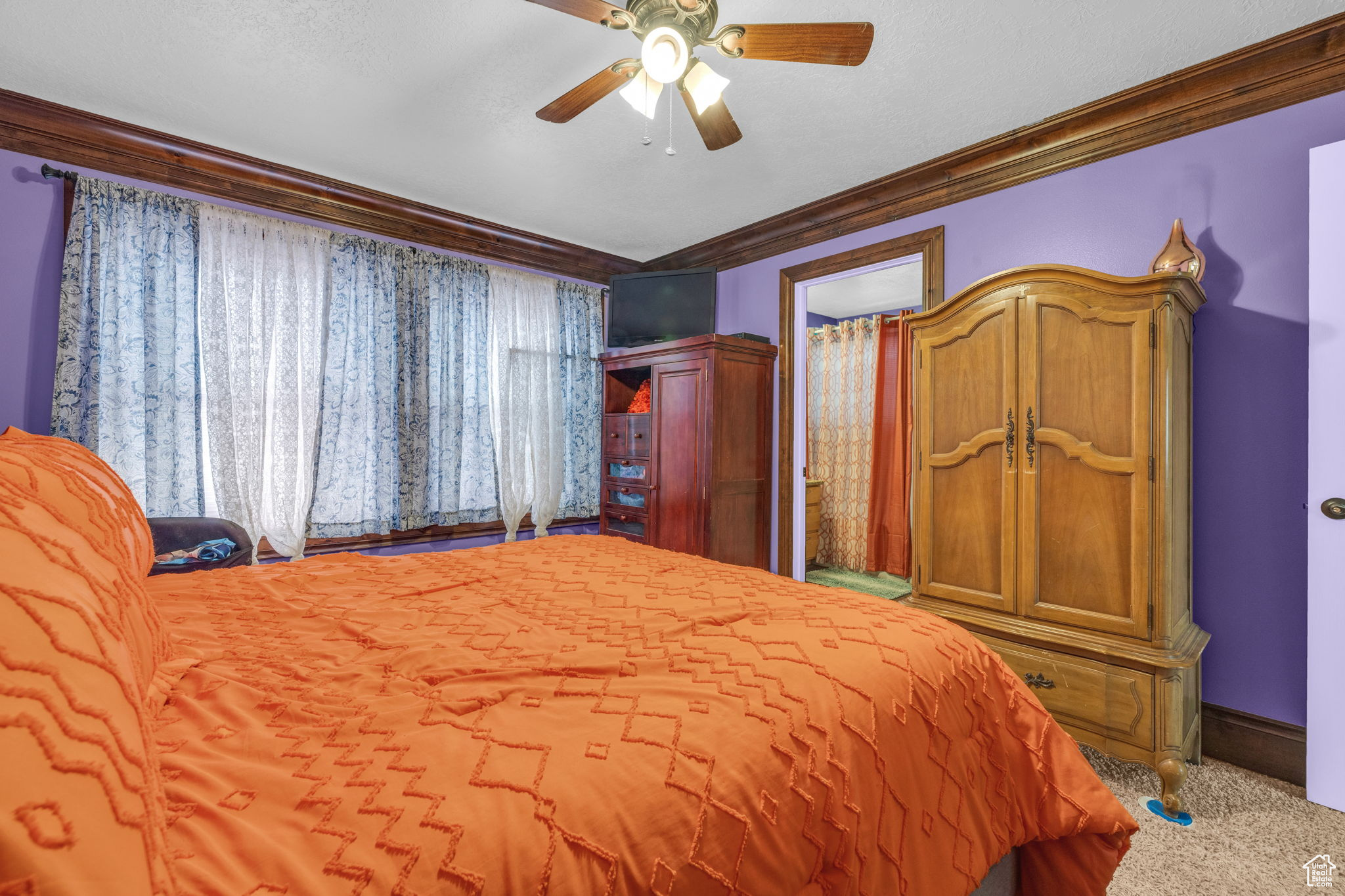 Bedroom with carpet floors, ornamental molding, and ceiling fan