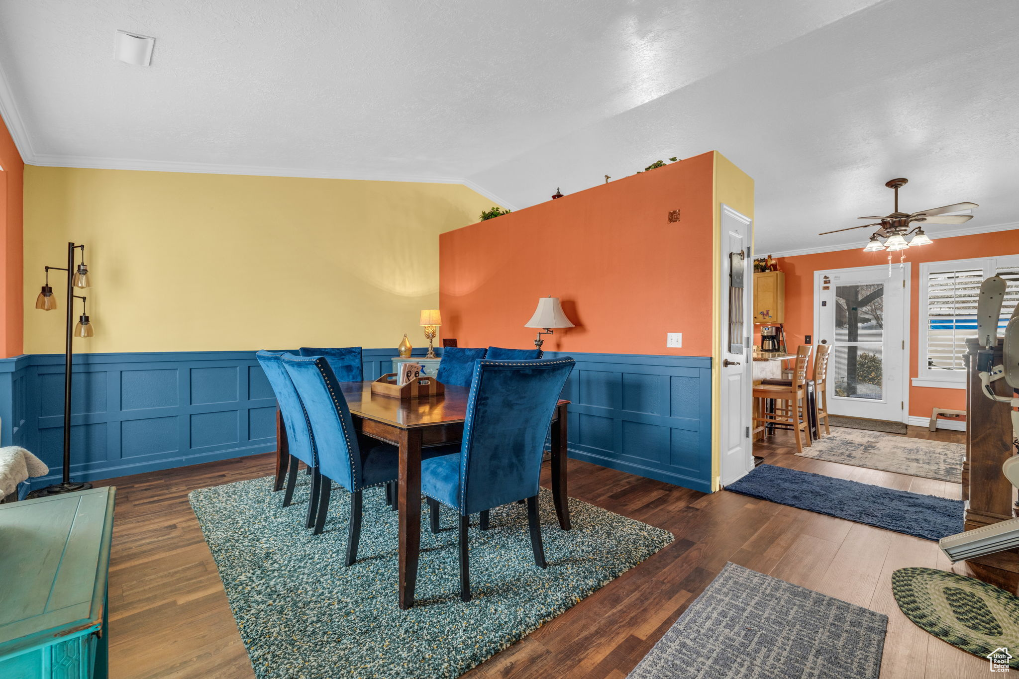 Dining space with vaulted ceiling, ornamental molding, dark hardwood / wood-style floors, and ceiling fan