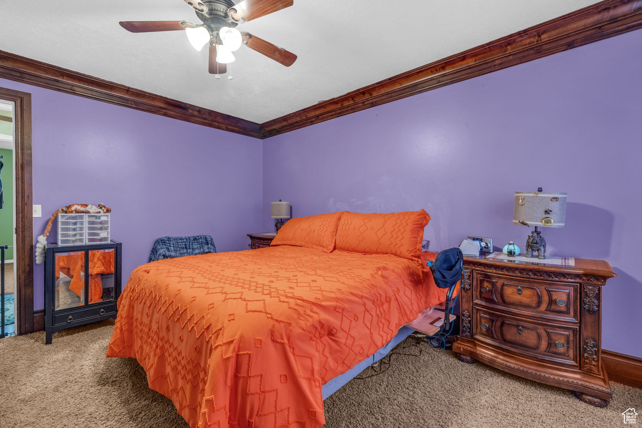 Carpeted bedroom with ornamental molding and ceiling fan