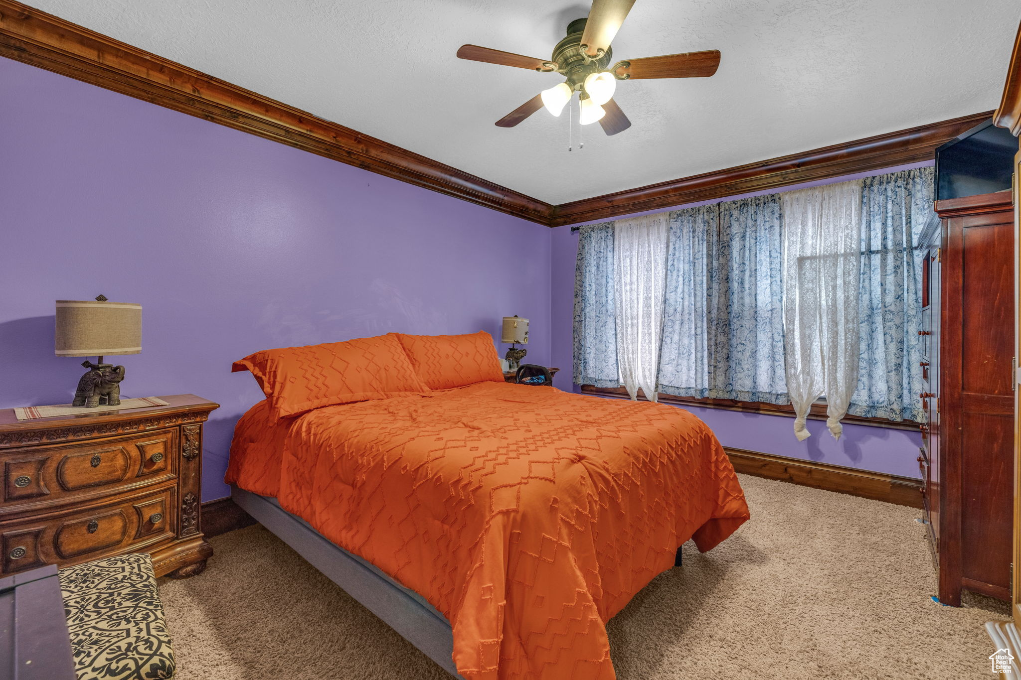 Carpeted bedroom featuring crown molding and ceiling fan