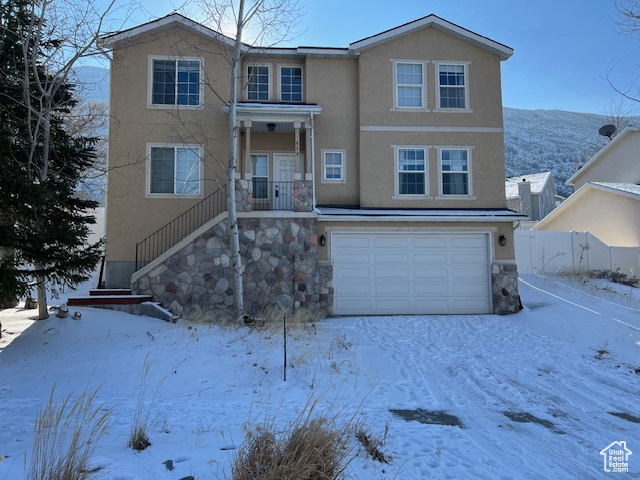 View of front of property with a mountain view and a garage