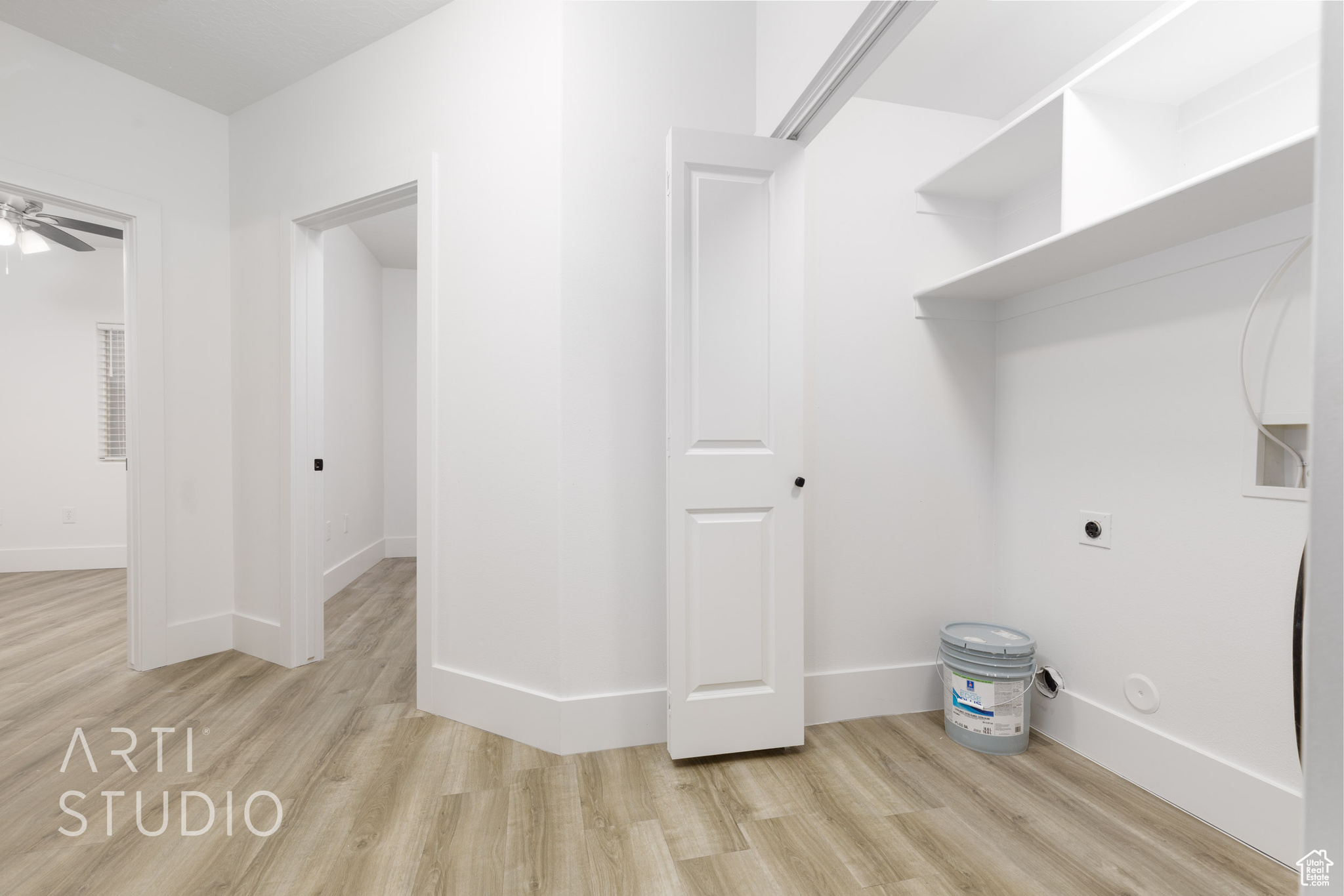Clothes washing area featuring ceiling fan, light wood-type flooring, and electric dryer hookup