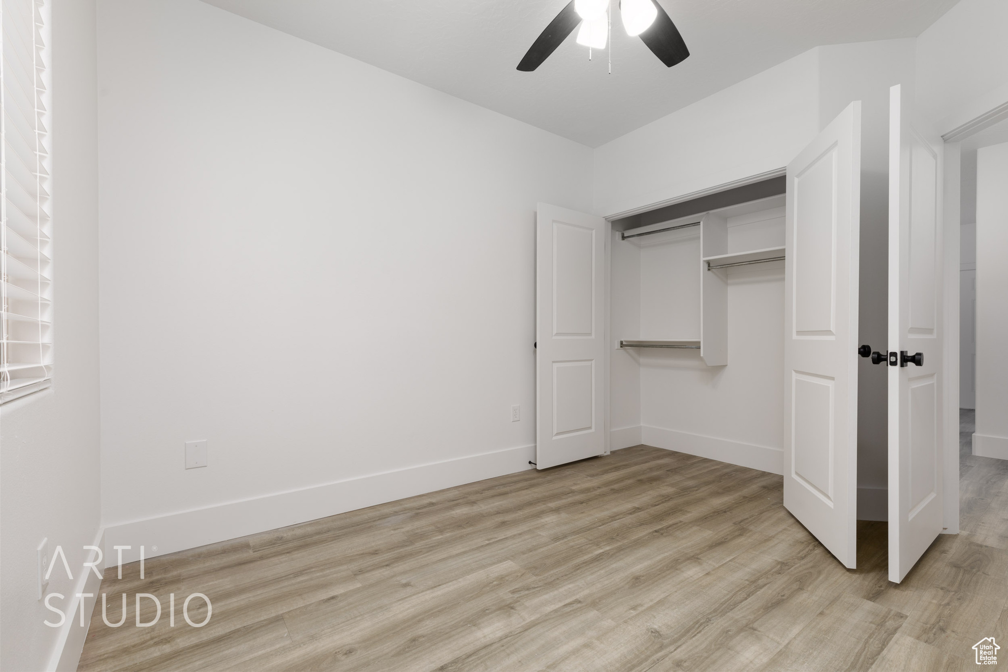 Unfurnished bedroom featuring ceiling fan, a closet, and light wood-type flooring