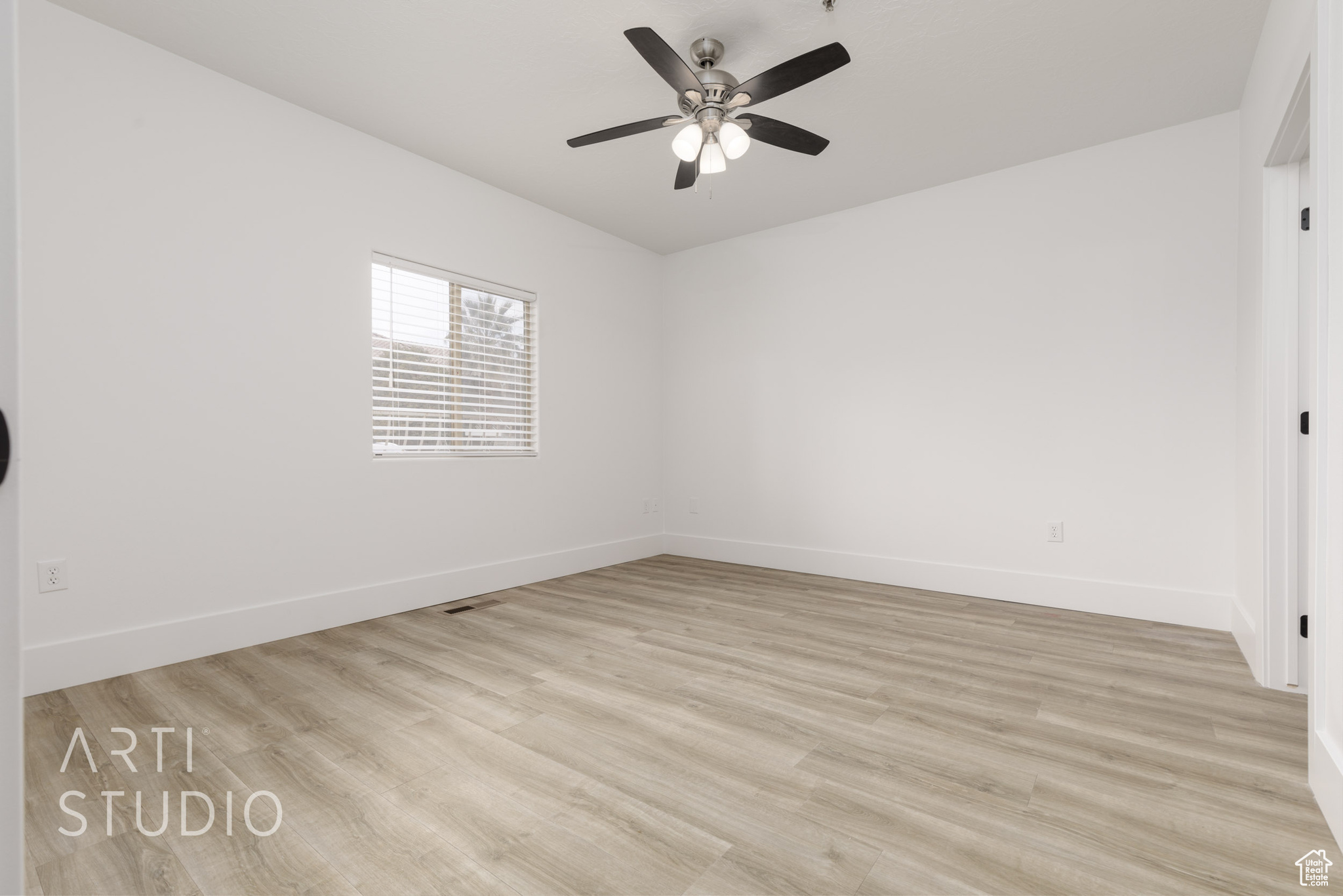 Spare room featuring ceiling fan and light hardwood / wood-style flooring