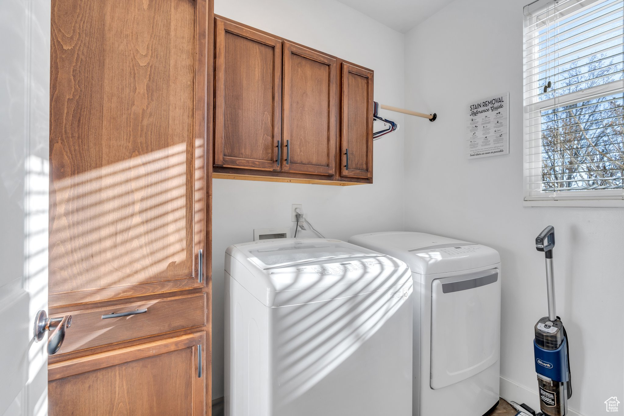 Clothes washing area featuring cabinets and independent washer and dryer