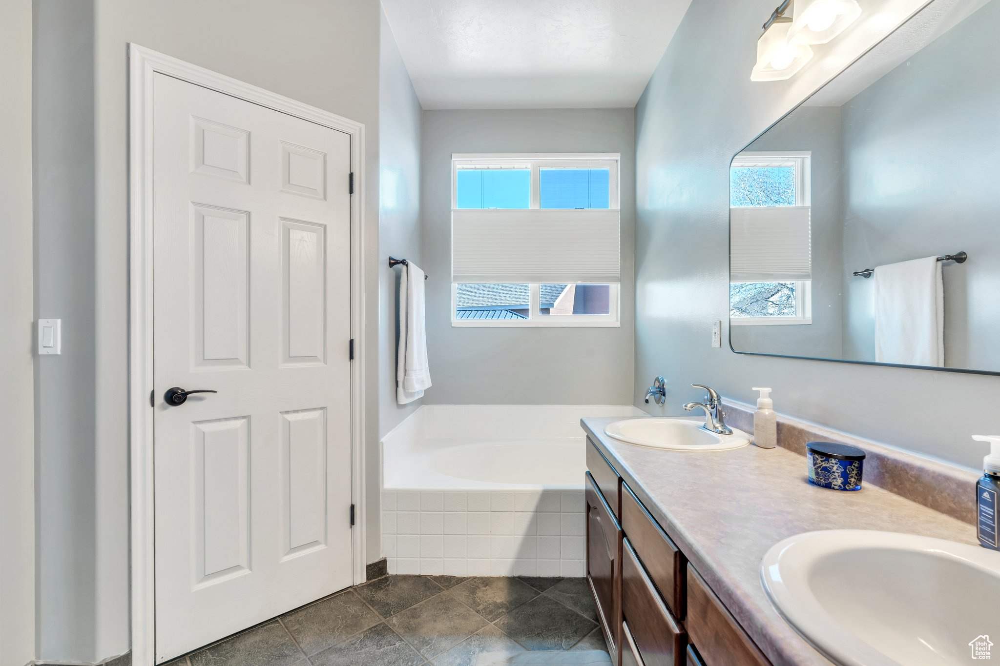 Bathroom featuring a relaxing tiled tub and vanity