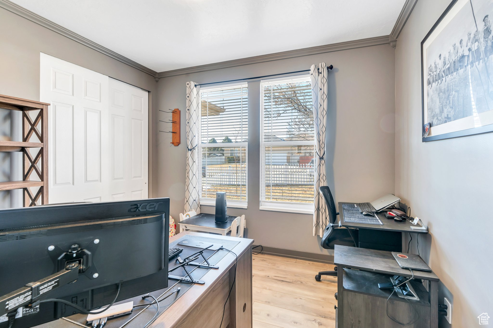 Office with ornamental molding and light wood-type flooring