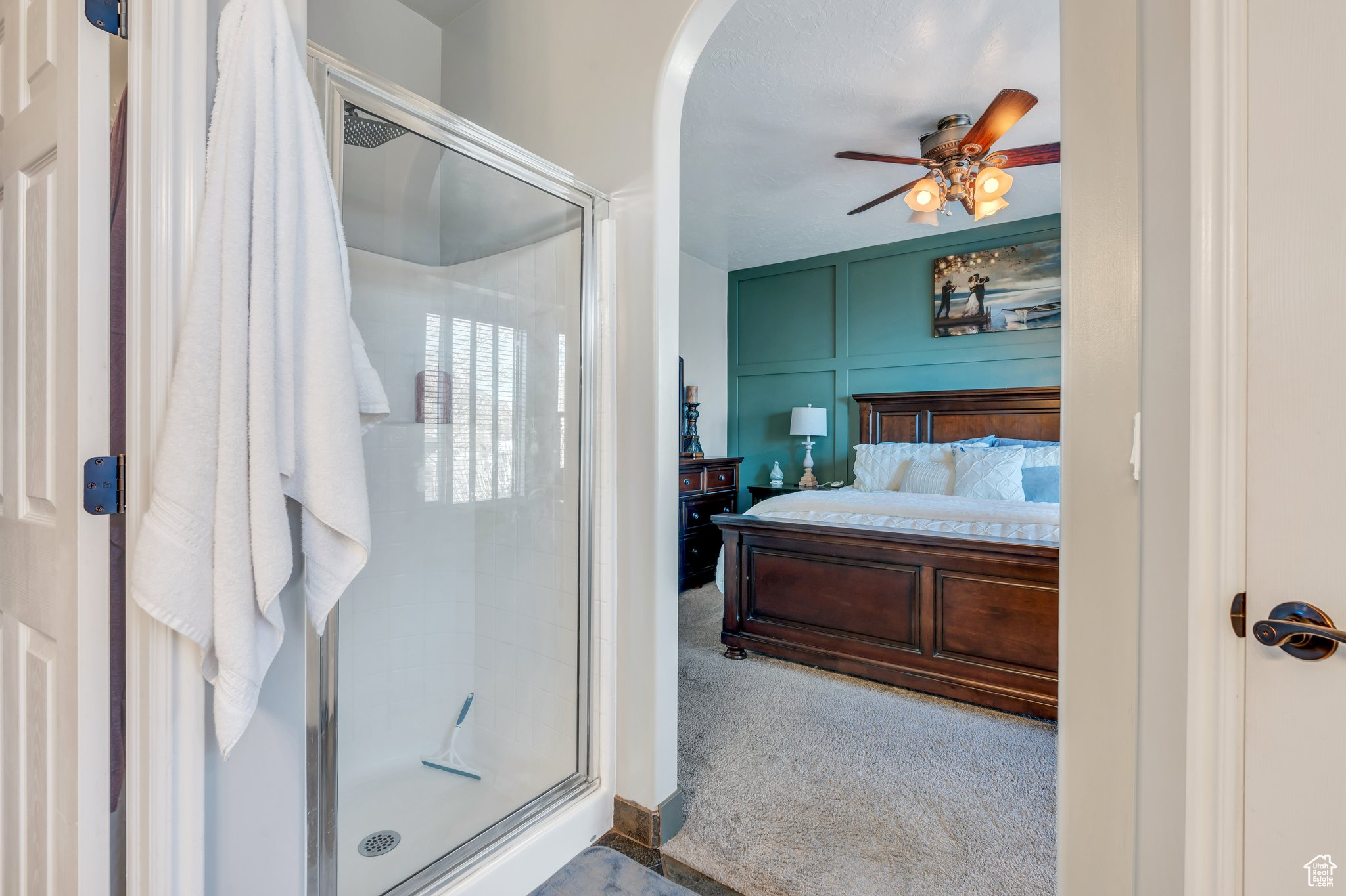 Carpeted bedroom featuring ceiling fan