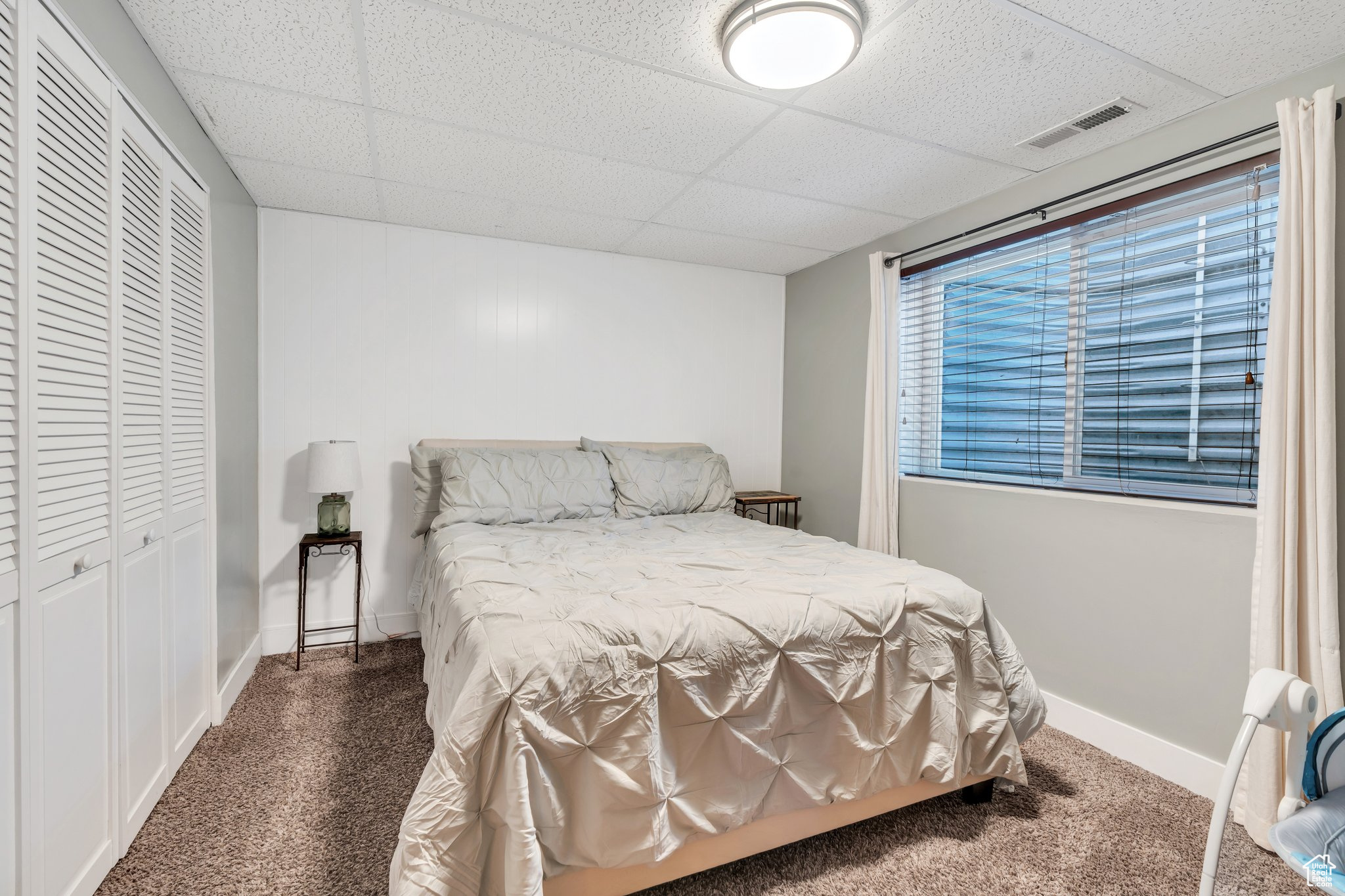 Carpeted bedroom with a paneled ceiling