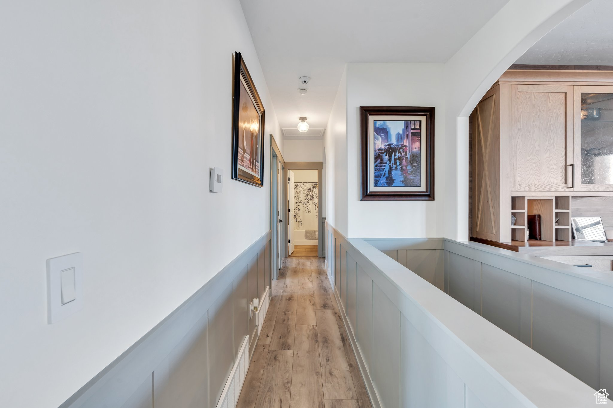 Hallway featuring built in features and light hardwood / wood-style flooring