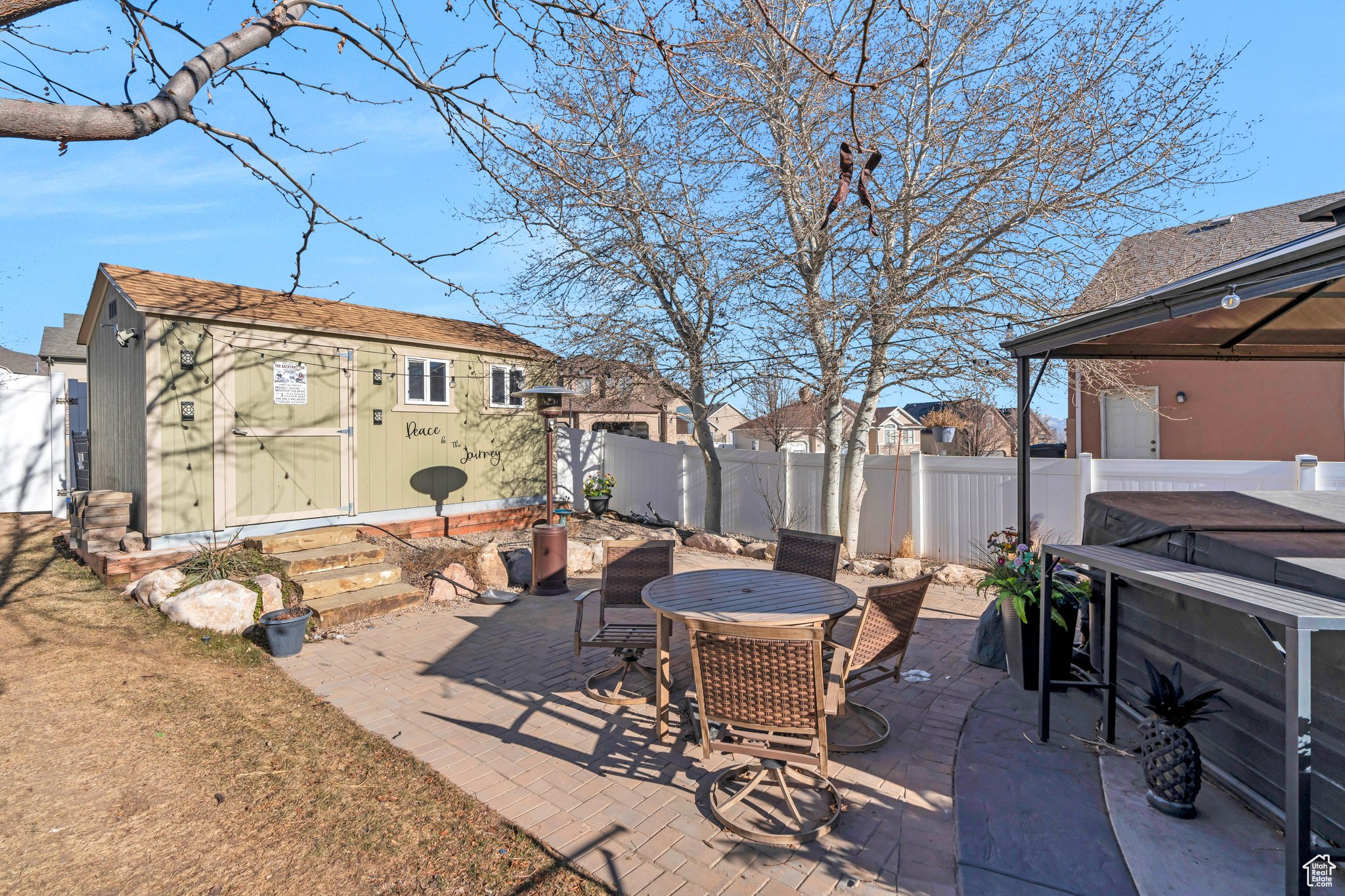 View of patio featuring a hot tub and a storage unit