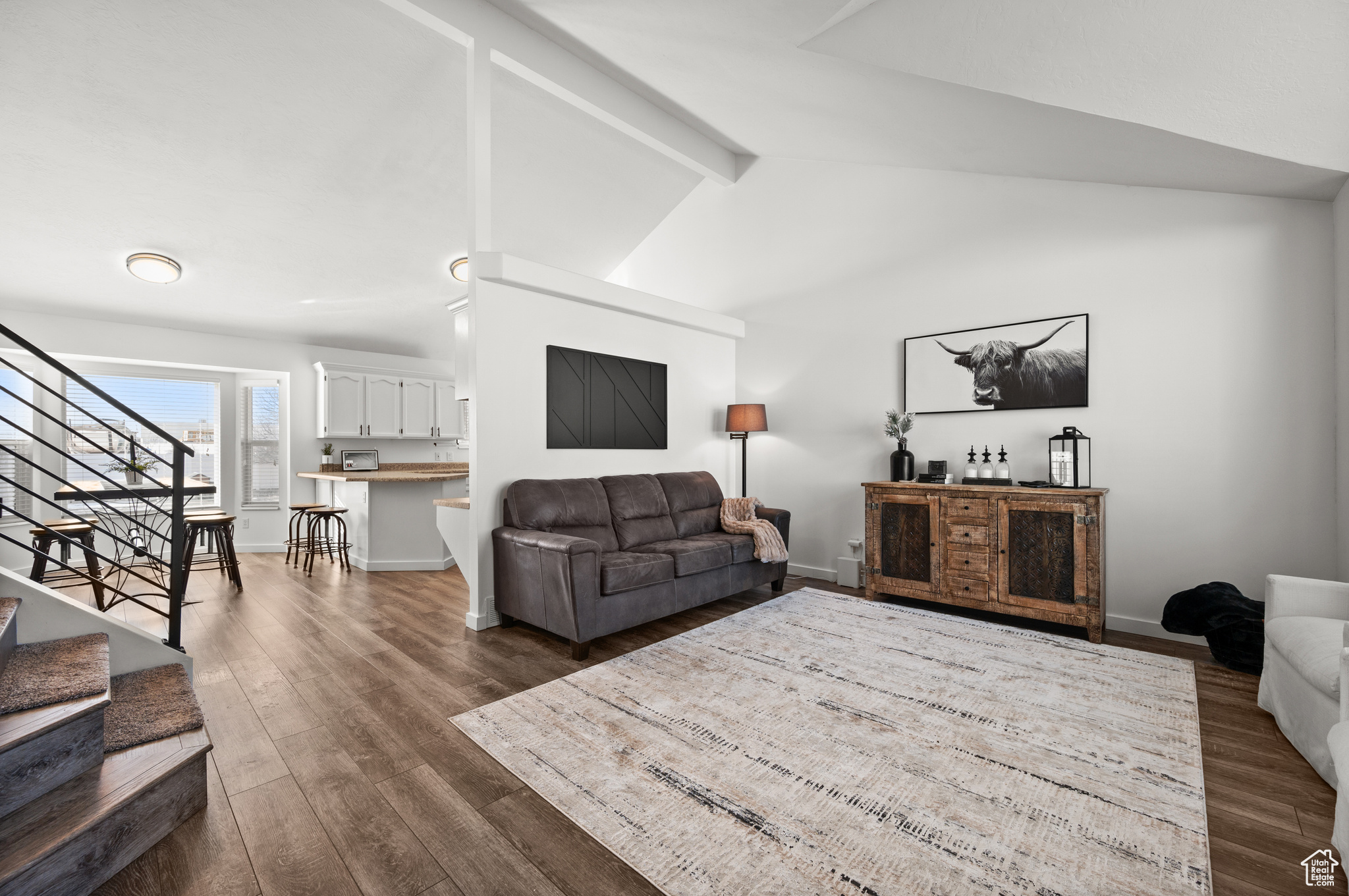 Living room with lofted ceiling with beams and dark hardwood / wood-style flooring