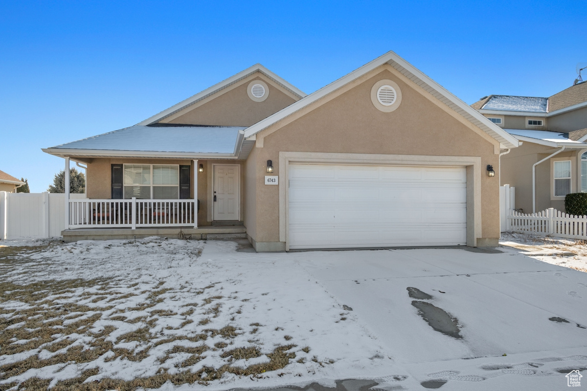 View of property with a porch and a garage