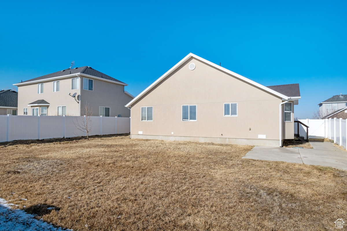 Rear view of house with a lawn and a patio area