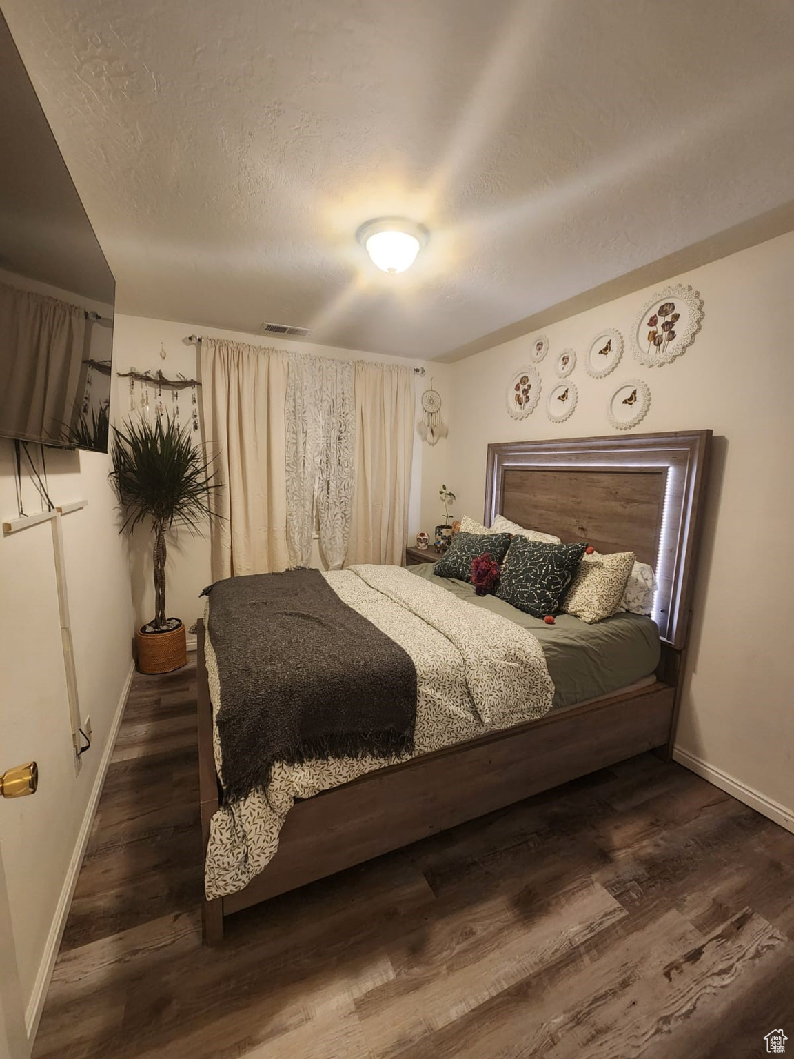 Bedroom featuring dark hardwood / wood-style floors and a textured ceiling