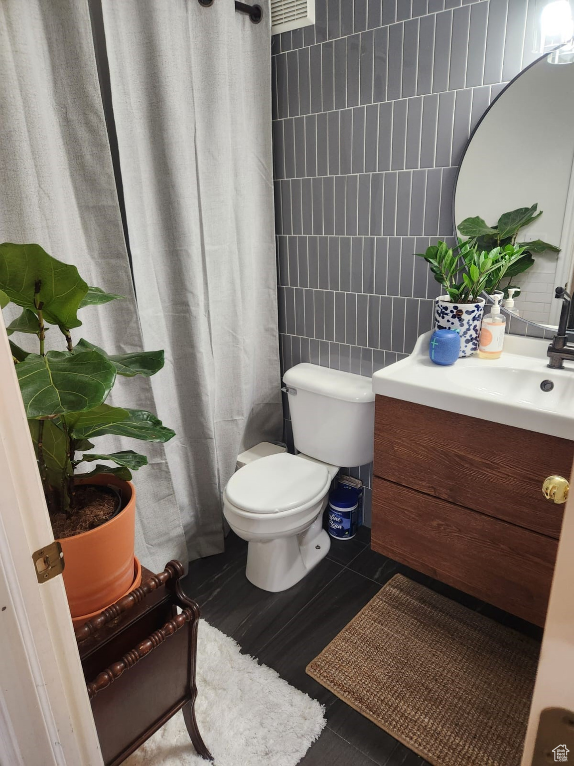 Bathroom with vanity, tile walls, a shower with shower curtain, and toilet