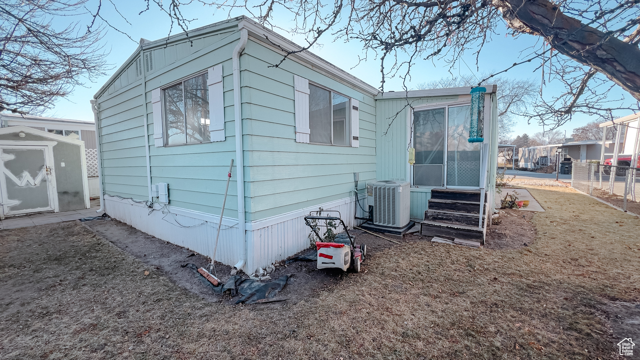 View of side of property featuring central AC and a shed