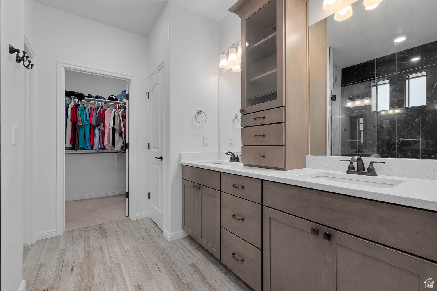 Bathroom featuring vanity, wood-type flooring, and a tile shower