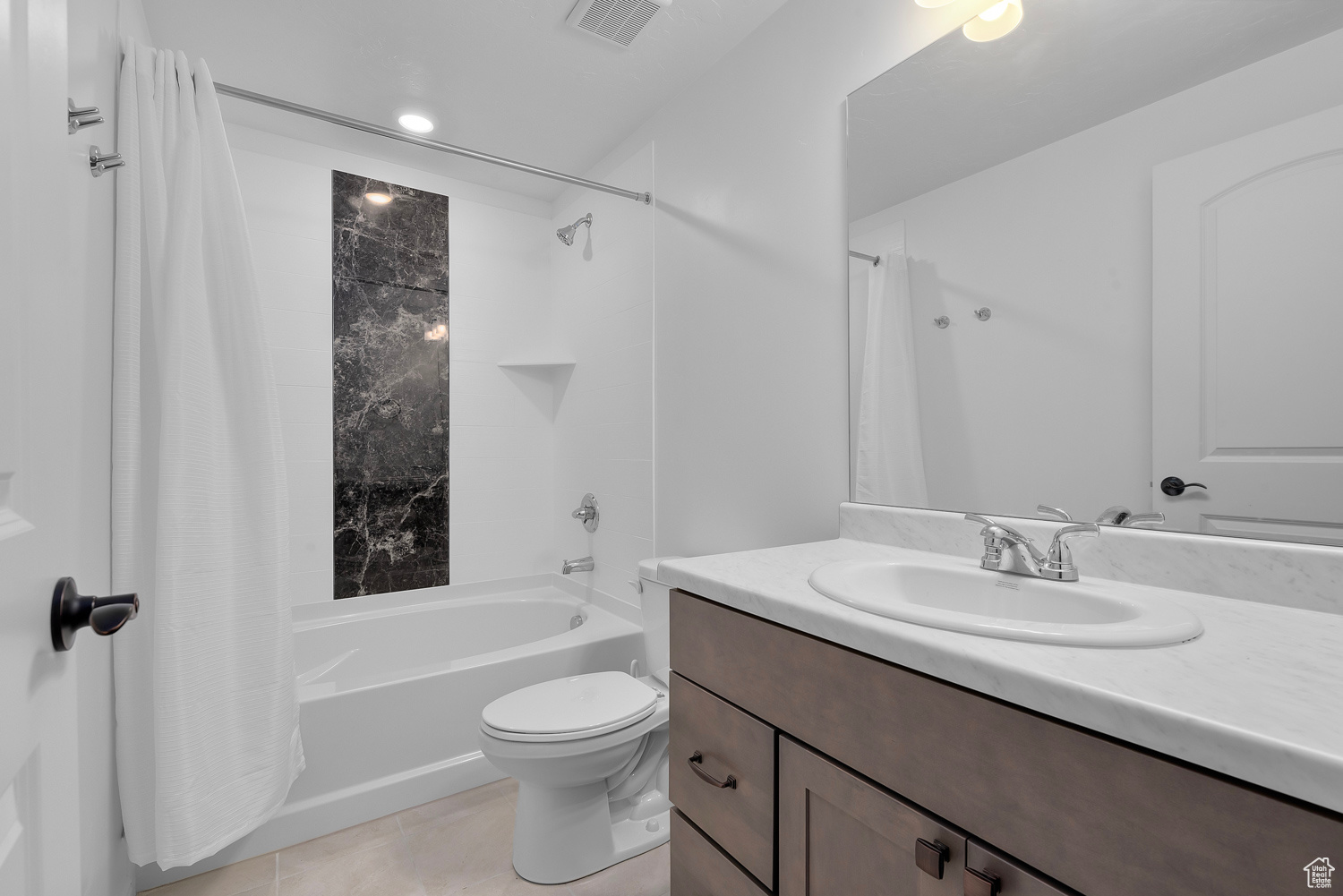 Full bathroom with vanity, tile patterned floors, shower / bath combination with curtain, and toilet