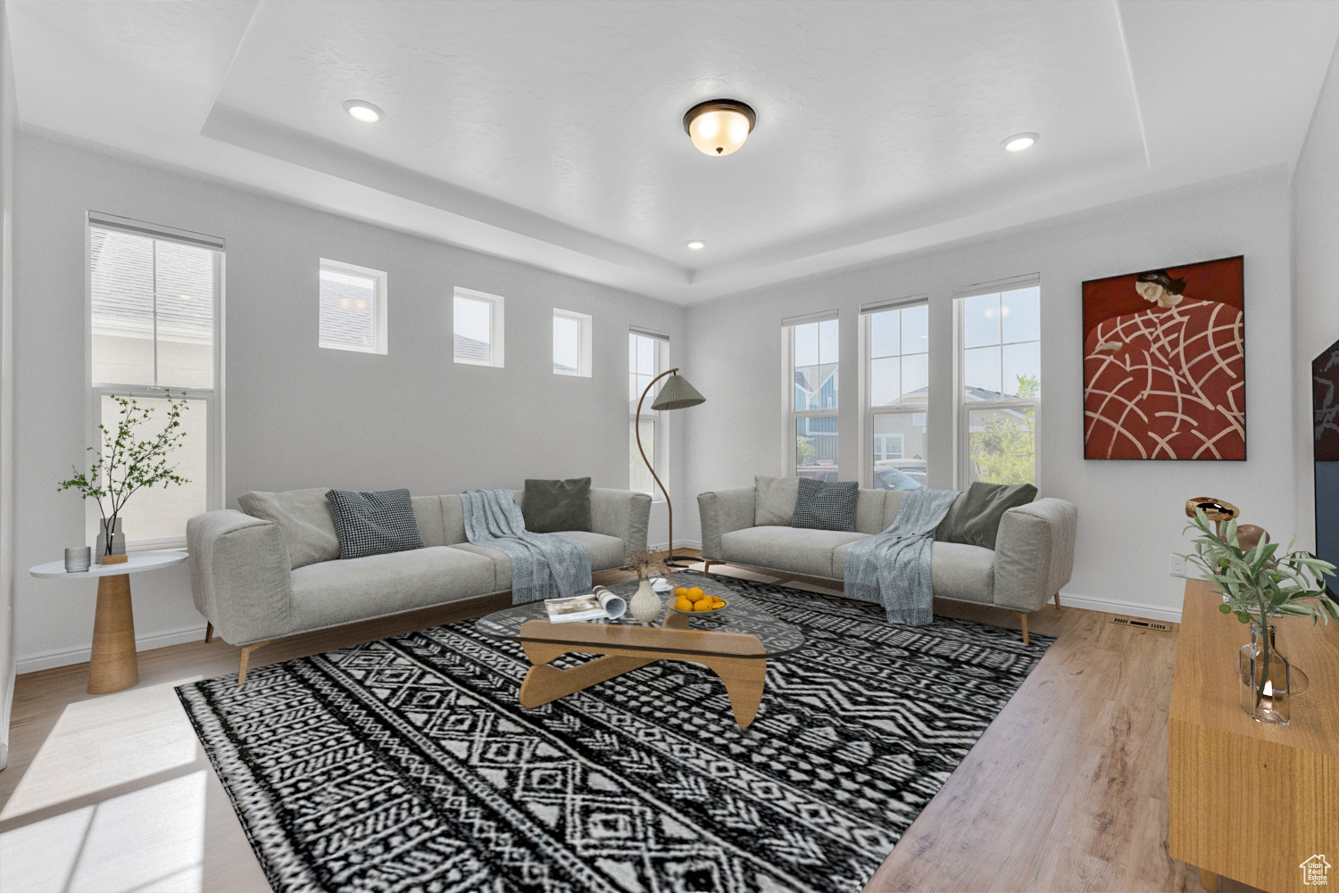 Living room with hardwood / wood-style flooring, plenty of natural light, and a tray ceiling