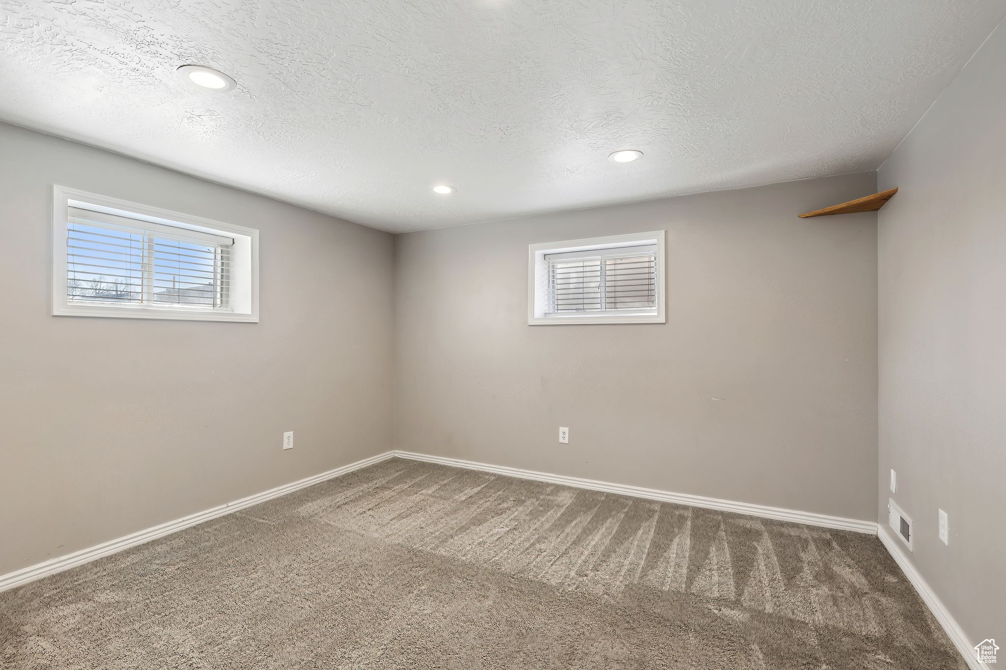 Carpeted empty room featuring a textured ceiling