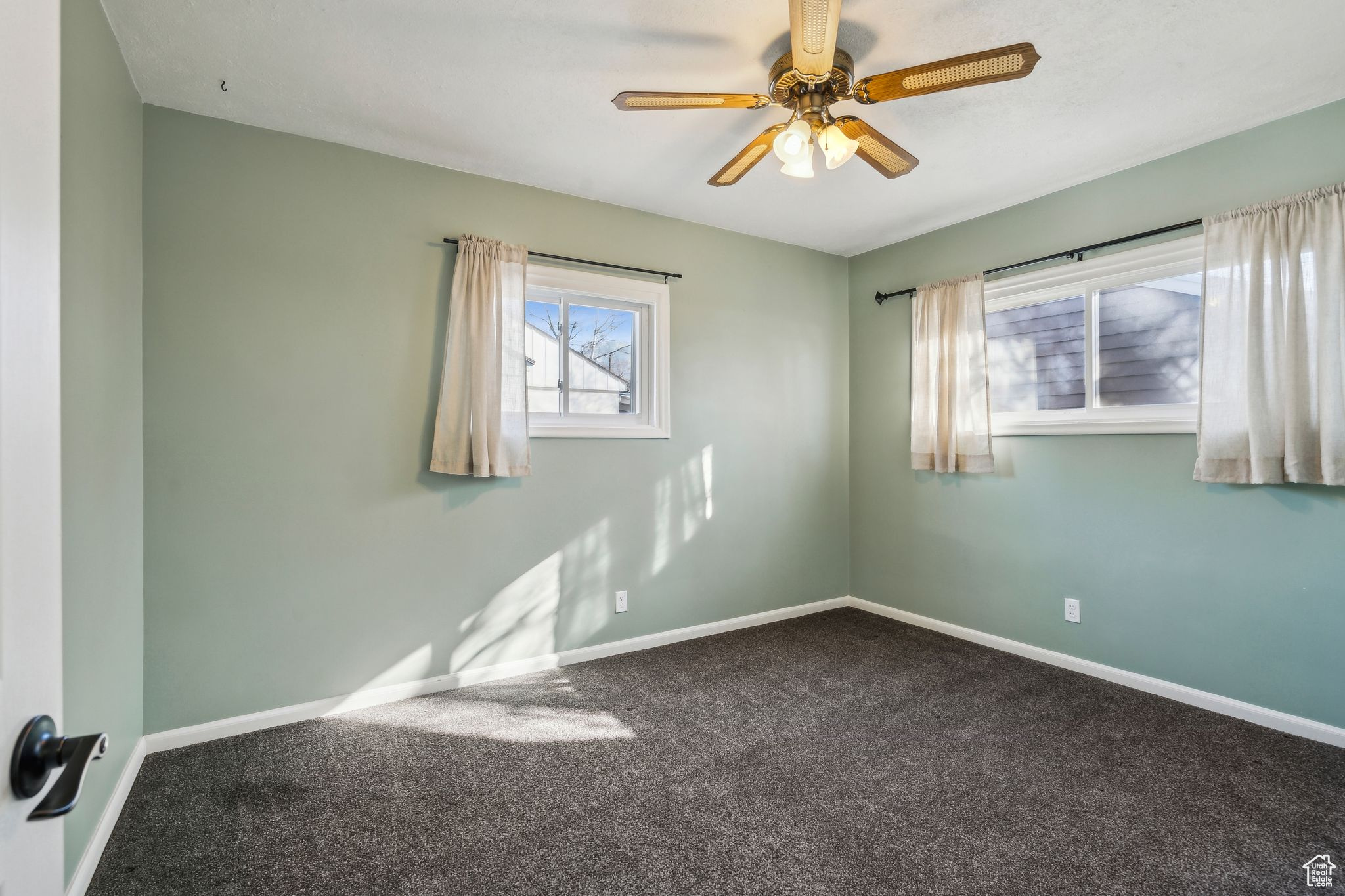 Carpeted empty room featuring ceiling fan