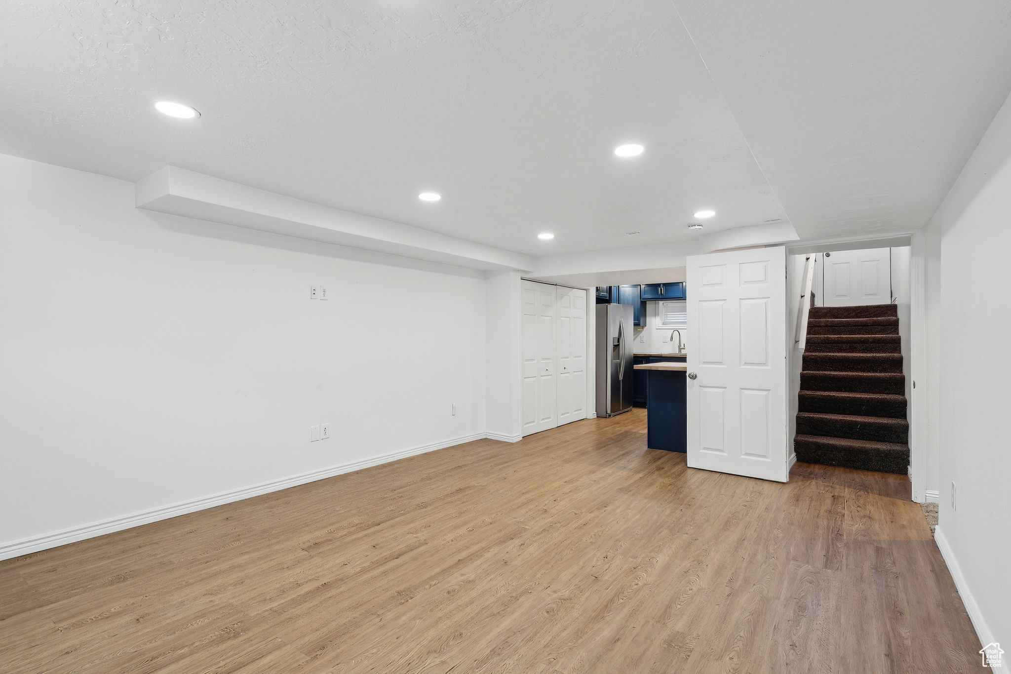 Interior space with stainless steel fridge, sink, and light hardwood / wood-style flooring