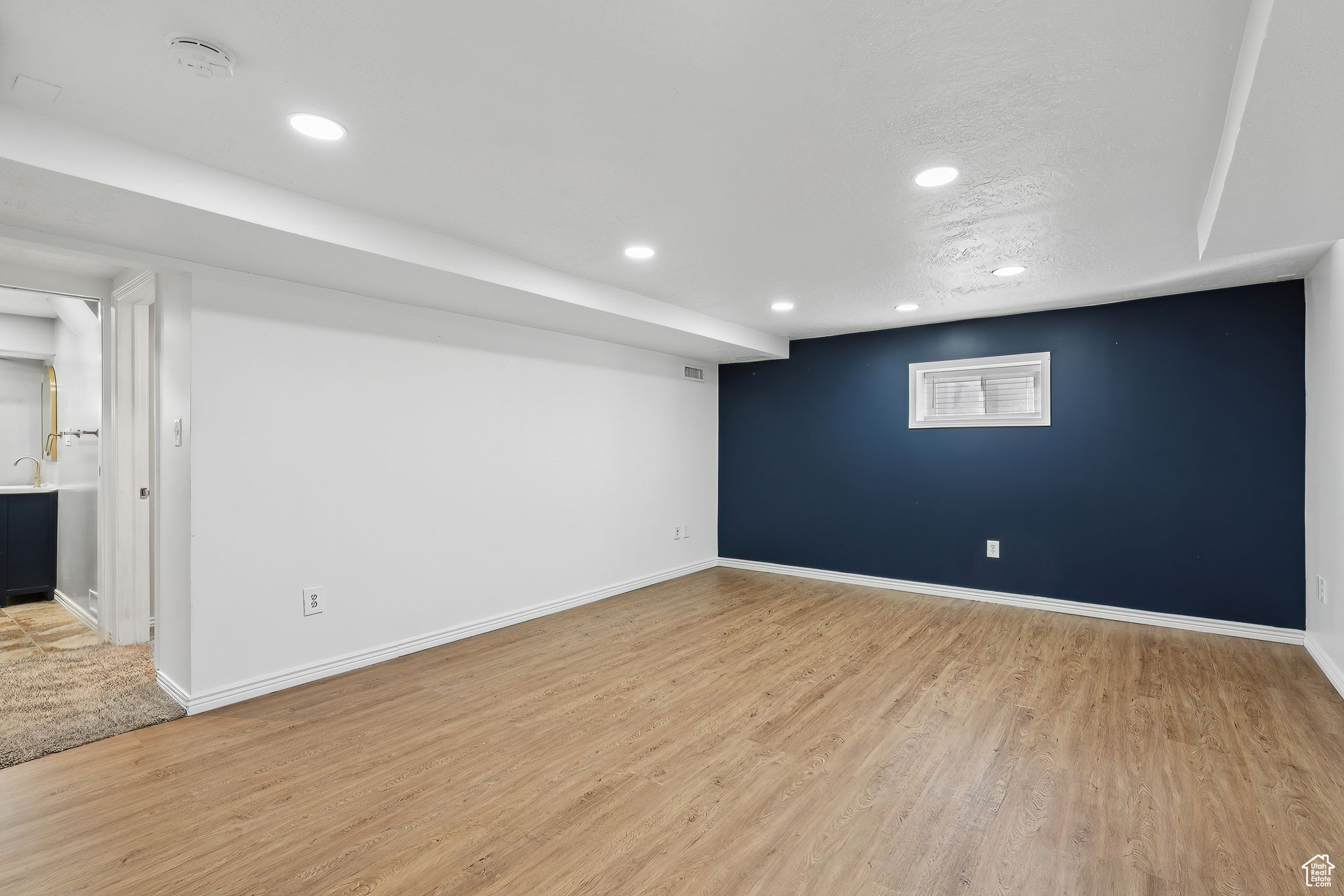 Basement featuring light hardwood / wood-style floors and a textured ceiling