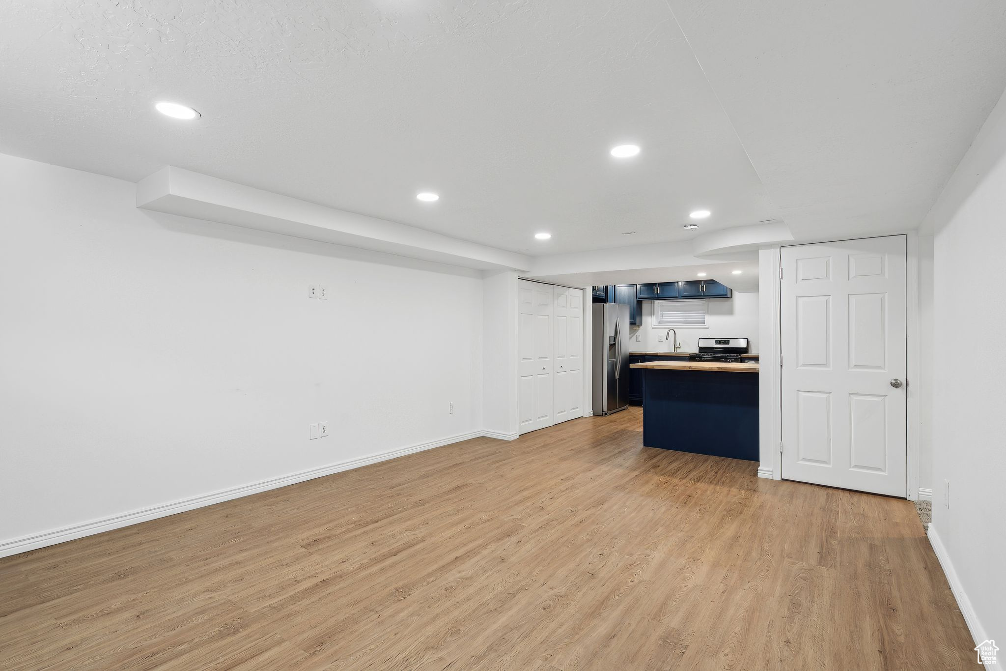 Unfurnished living room with hardwood / wood-style floors and sink