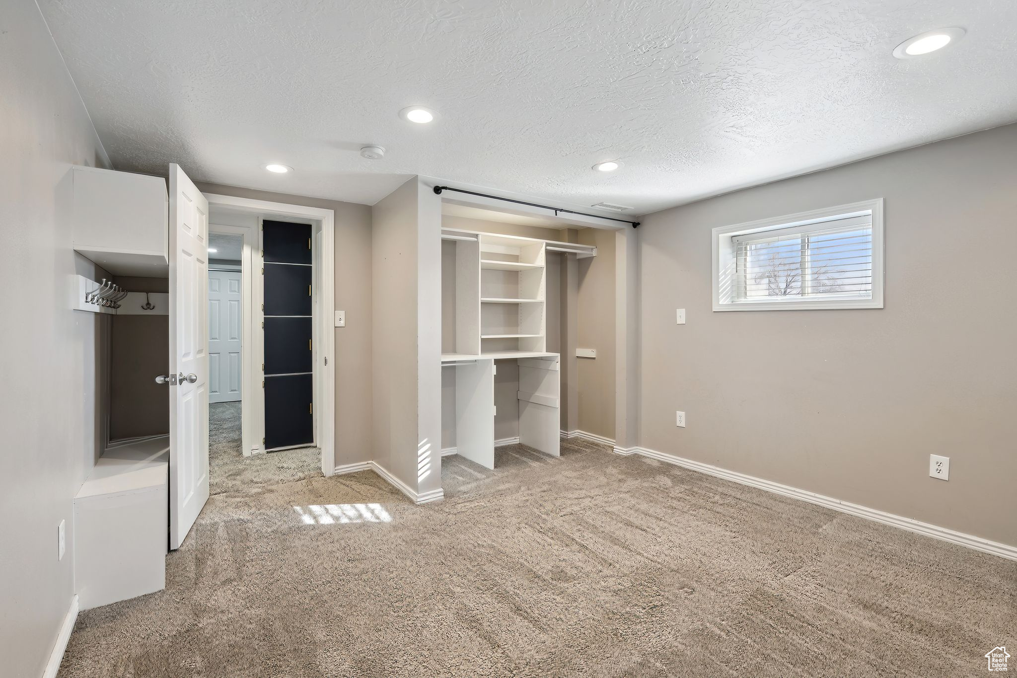 Unfurnished bedroom with light colored carpet, a closet, and a textured ceiling