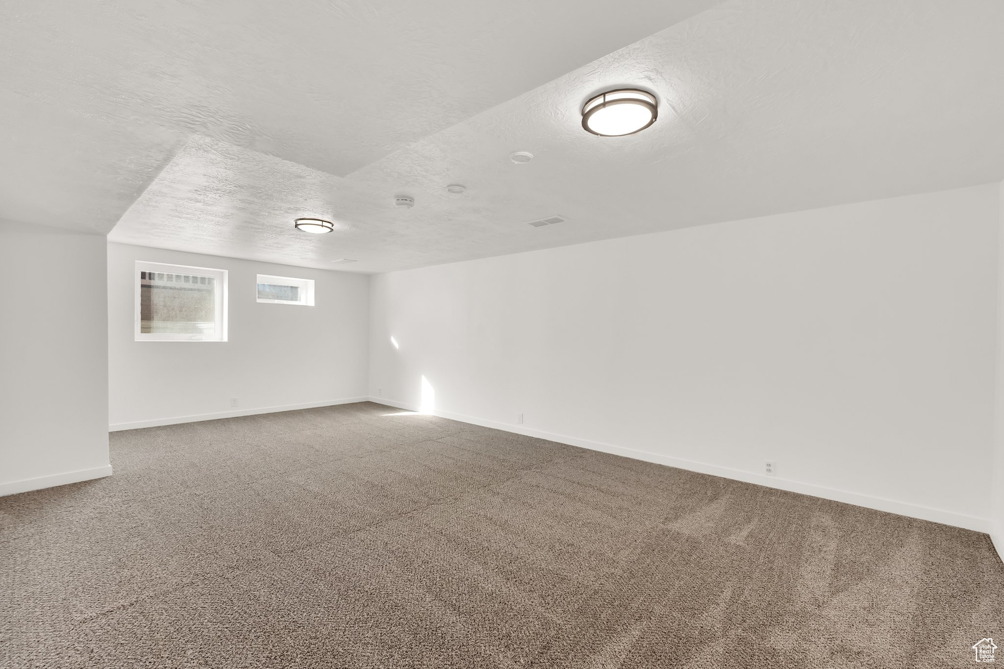 Empty room with carpet flooring and a textured ceiling