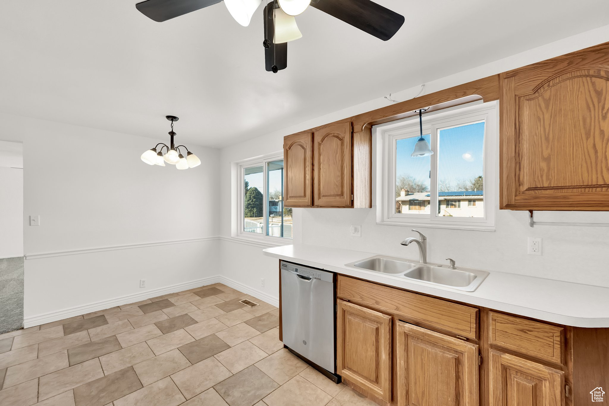 Kitchen with pendant lighting, sink, stainless steel dishwasher, and ceiling fan