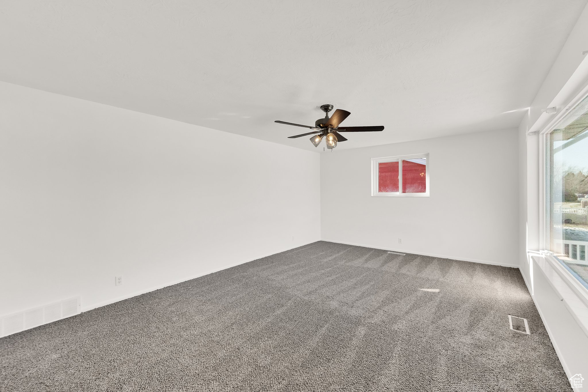 Unfurnished room with ceiling fan and carpet