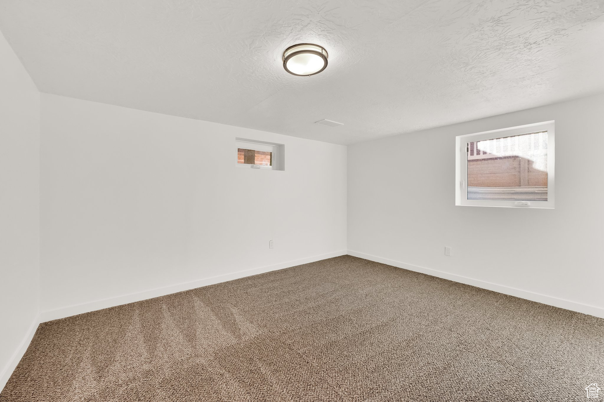 Carpeted empty room featuring a textured ceiling